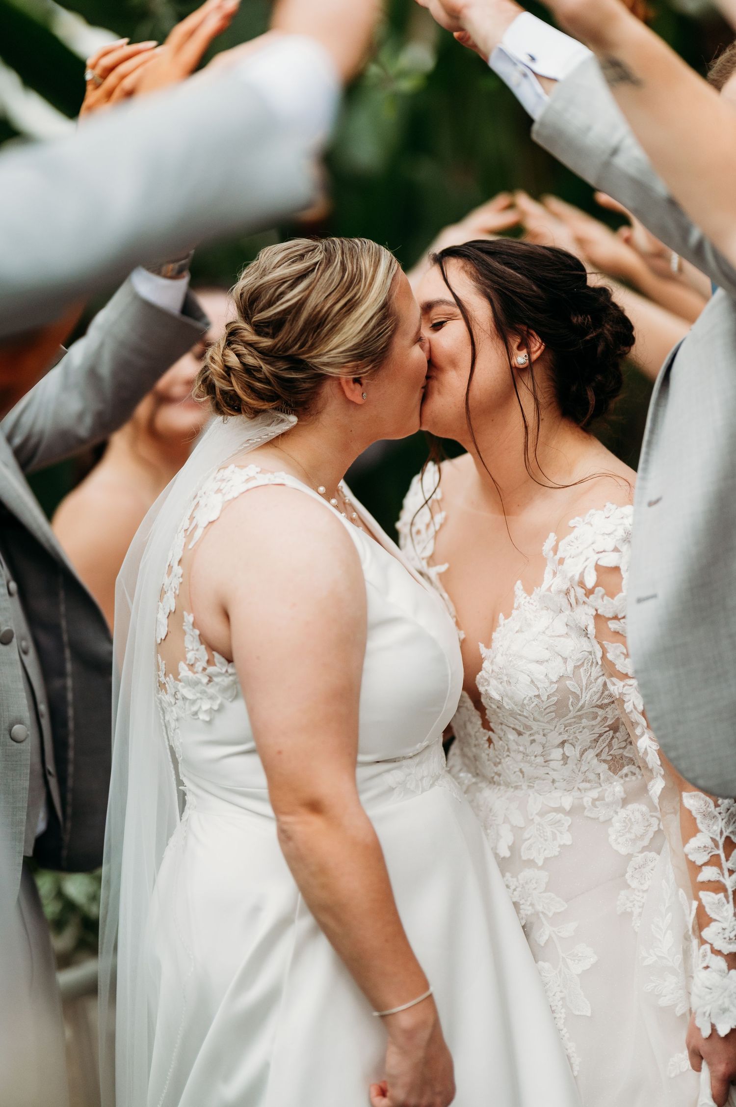 Group of people in white wedding dresses stand together during a celebration.