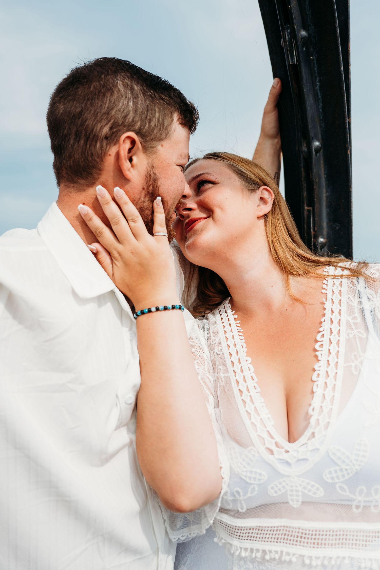 A romantic close-up sequence shows a tender moment between two people in white attire against a dark background.