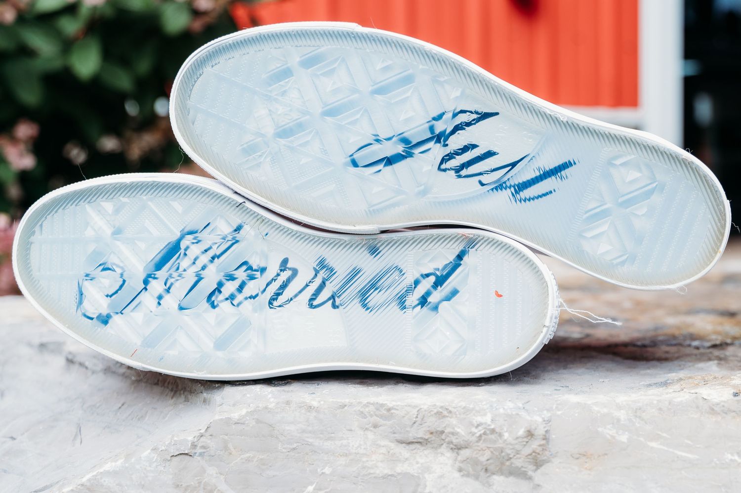 Wedding shoes with 'Just Married' written in blue script on the soles displayed against a light background.