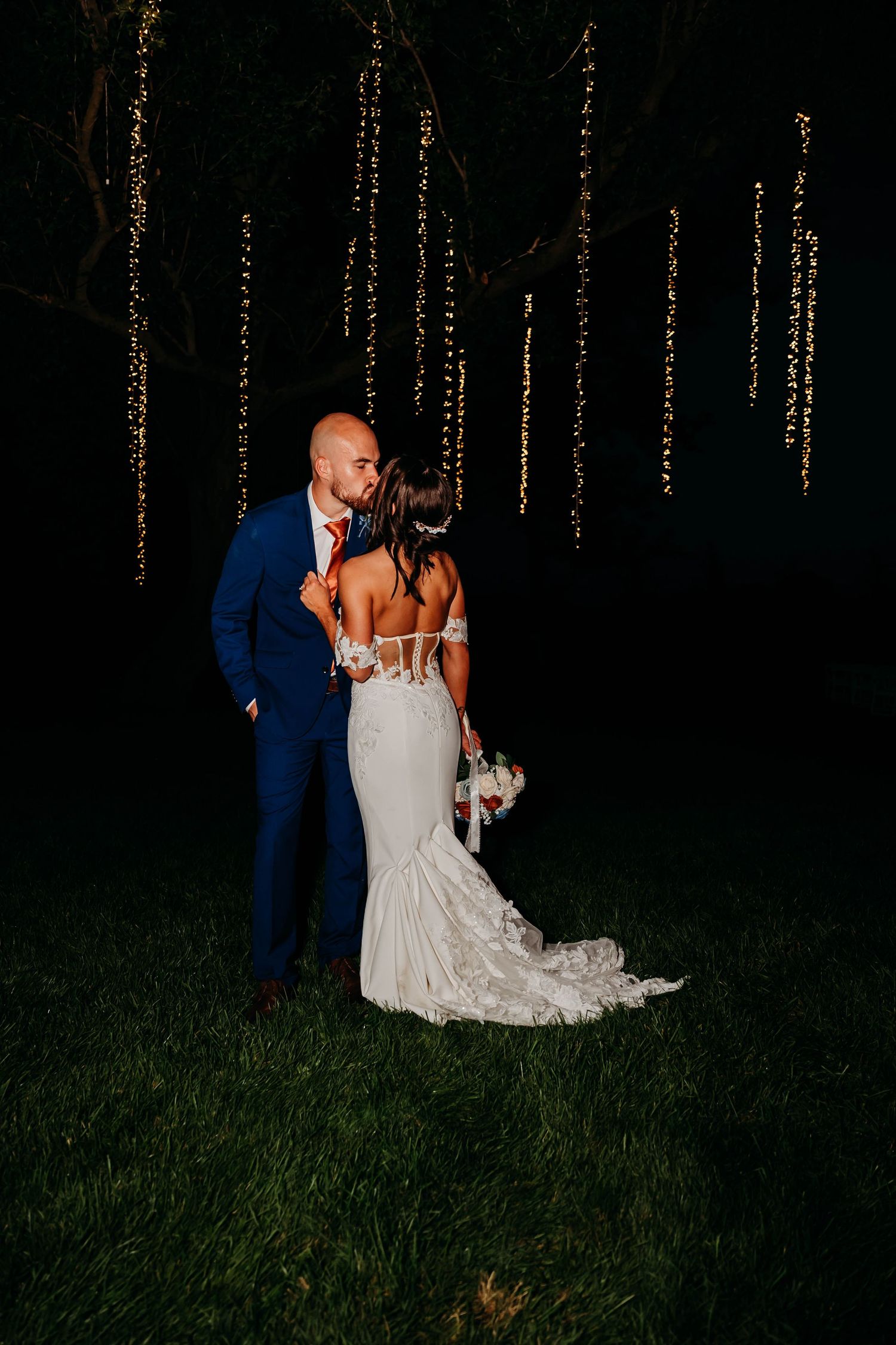 A romantic nighttime wedding photo series with string lights showing a couple embracing in an outdoor setting.