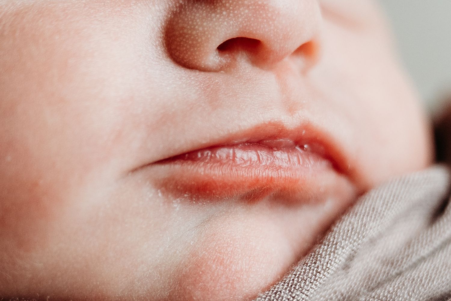 A close-up macro shot of pink lips and skin texture showing facial details.