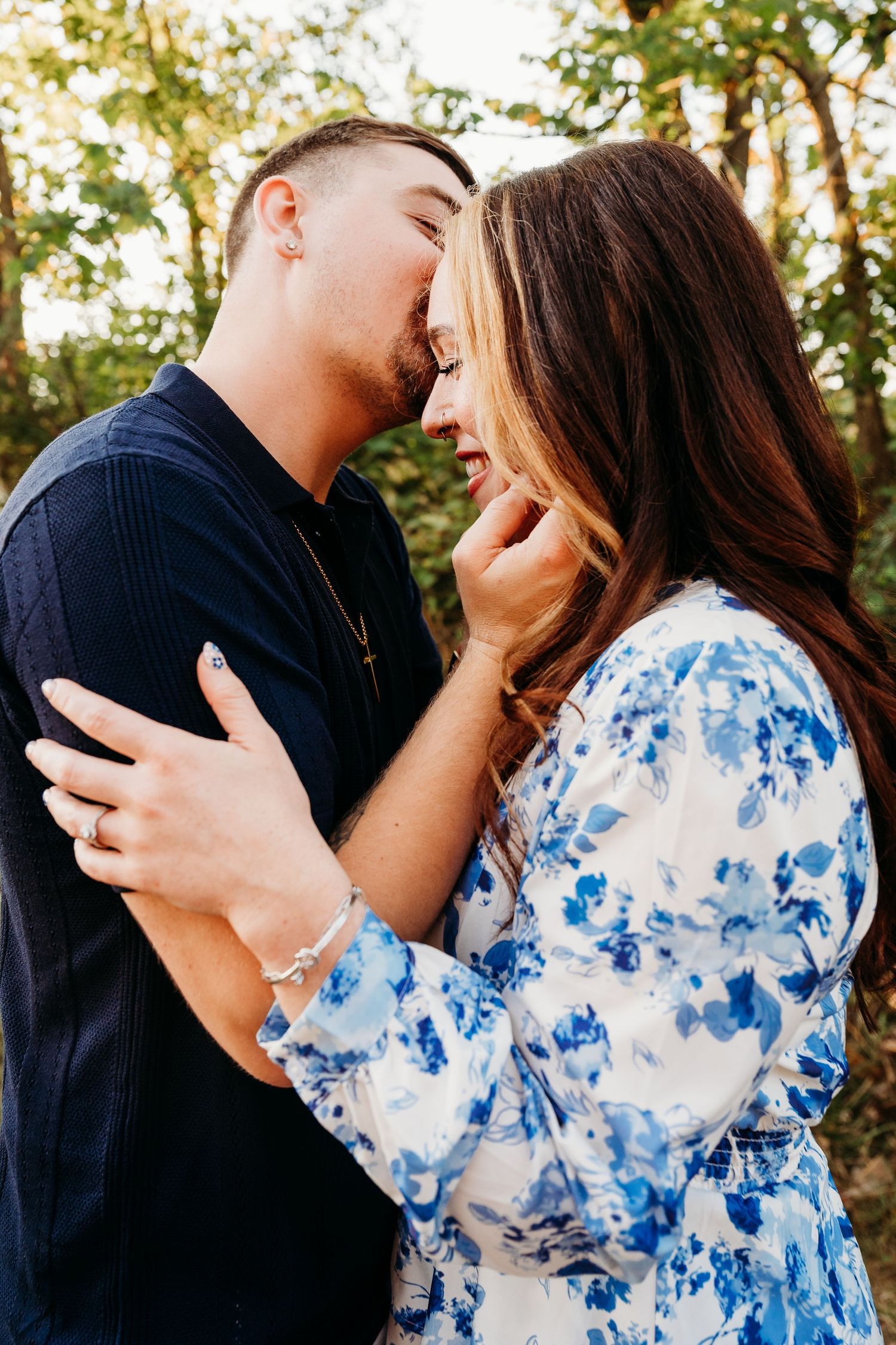 A couple in a navy shirt and blue floral dress share intimate romantic moments in an outdoor photo collage.