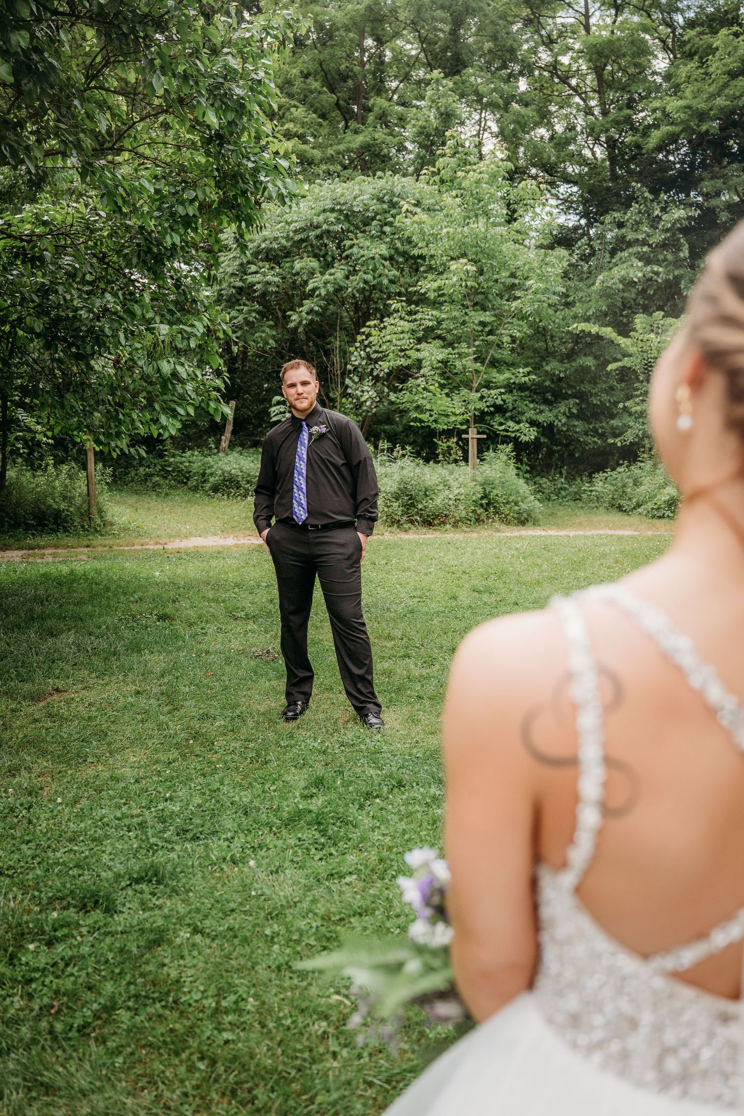 First look moment between a groom and bride in an elegant outdoor garden wedding setting.