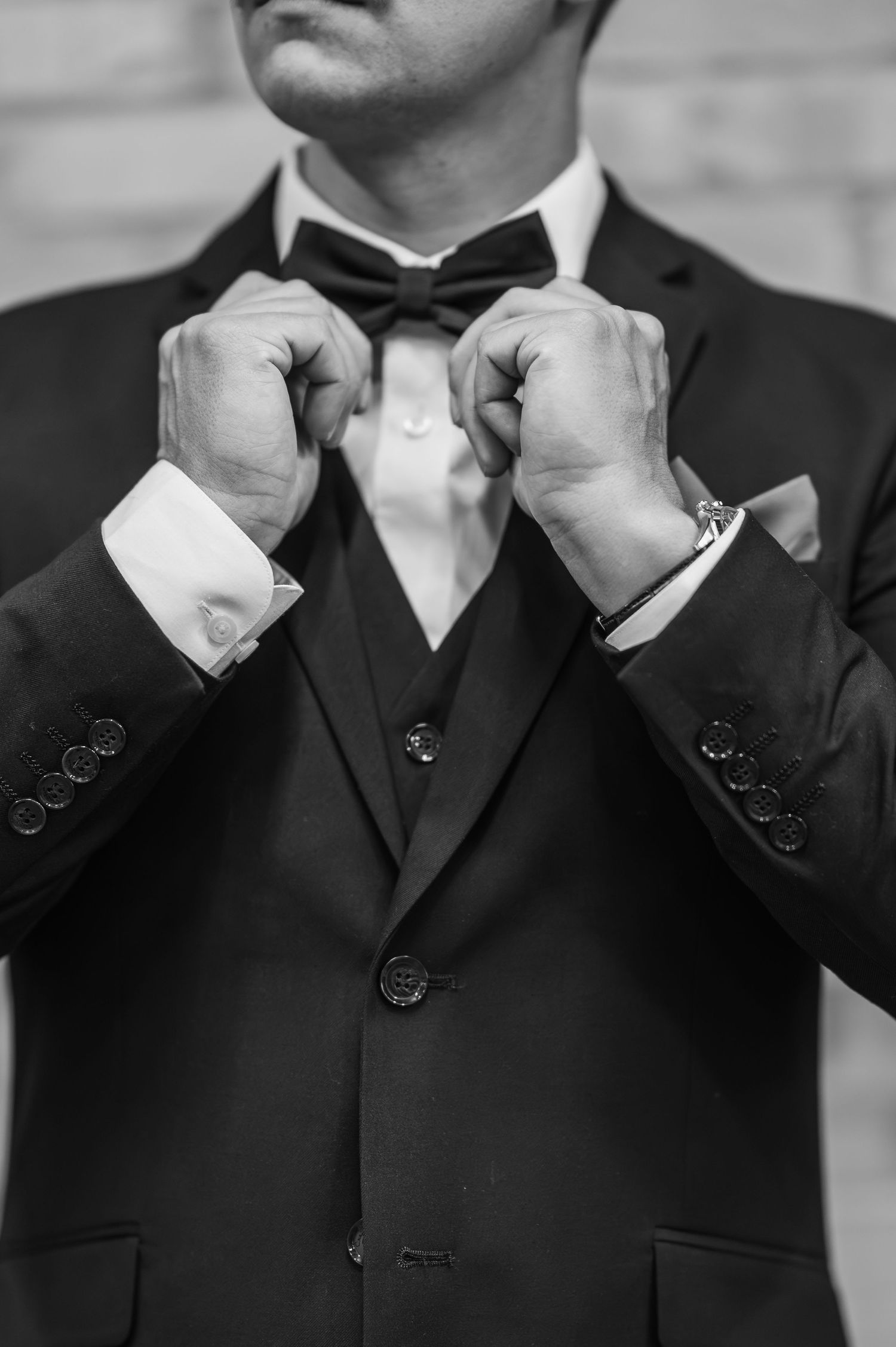 A series of black and white close-up photos showing groomsmen adjusting their bow ties.
