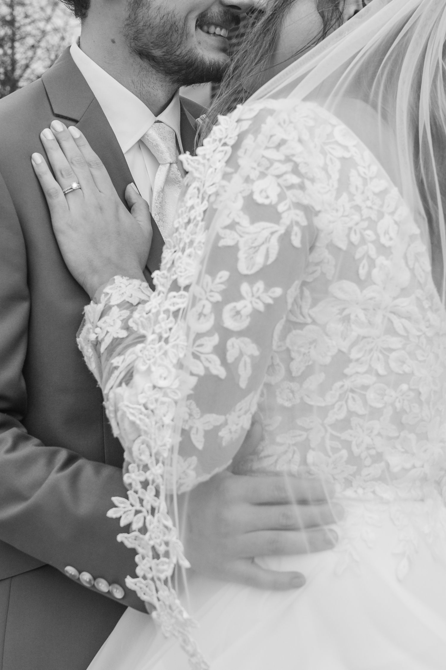 Close-up details of delicate lace on a white wedding dress.