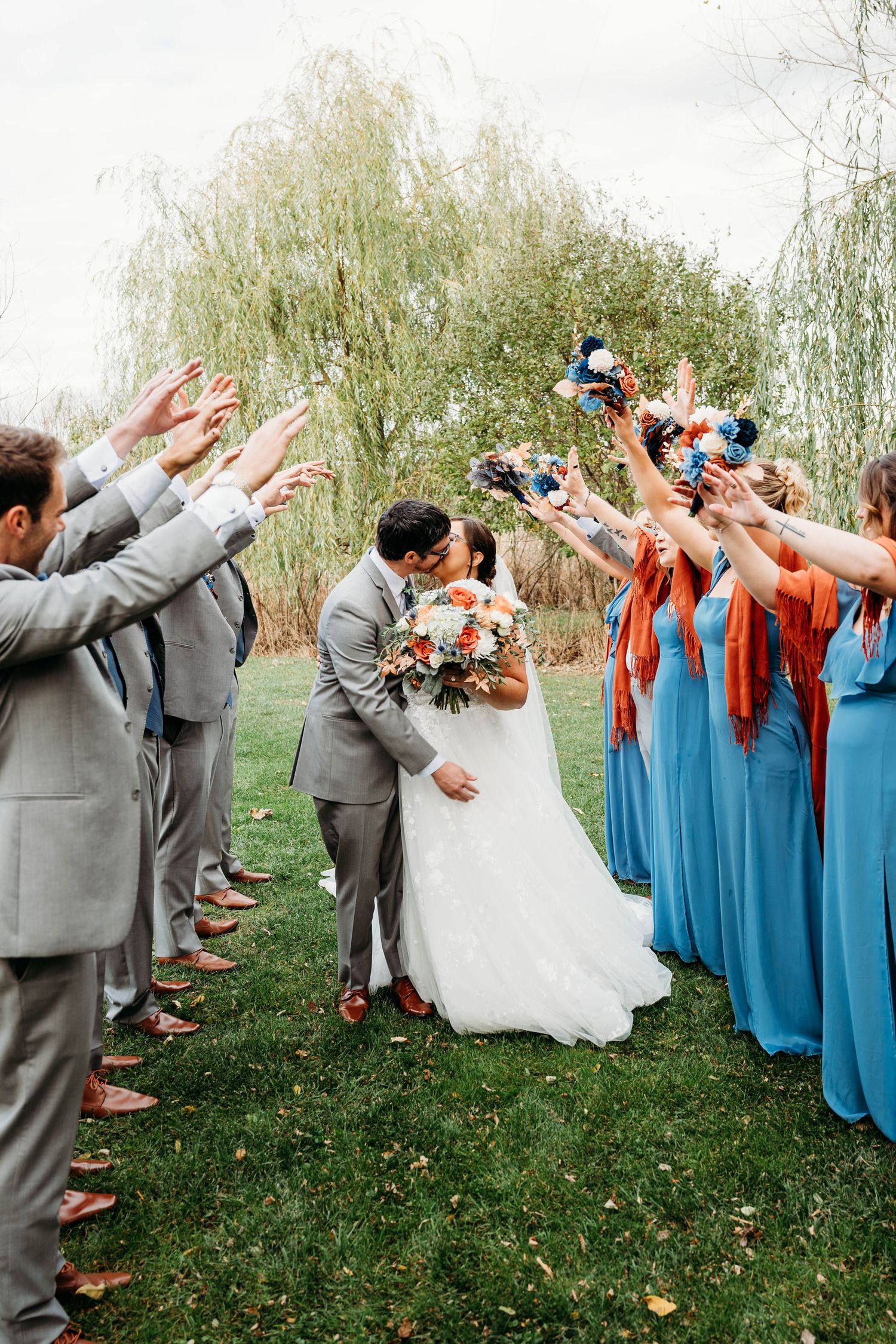Wedding party performs synchronized dabbing pose in sequence with groomsmen in gray suits and bridesmaids in blue dresses.