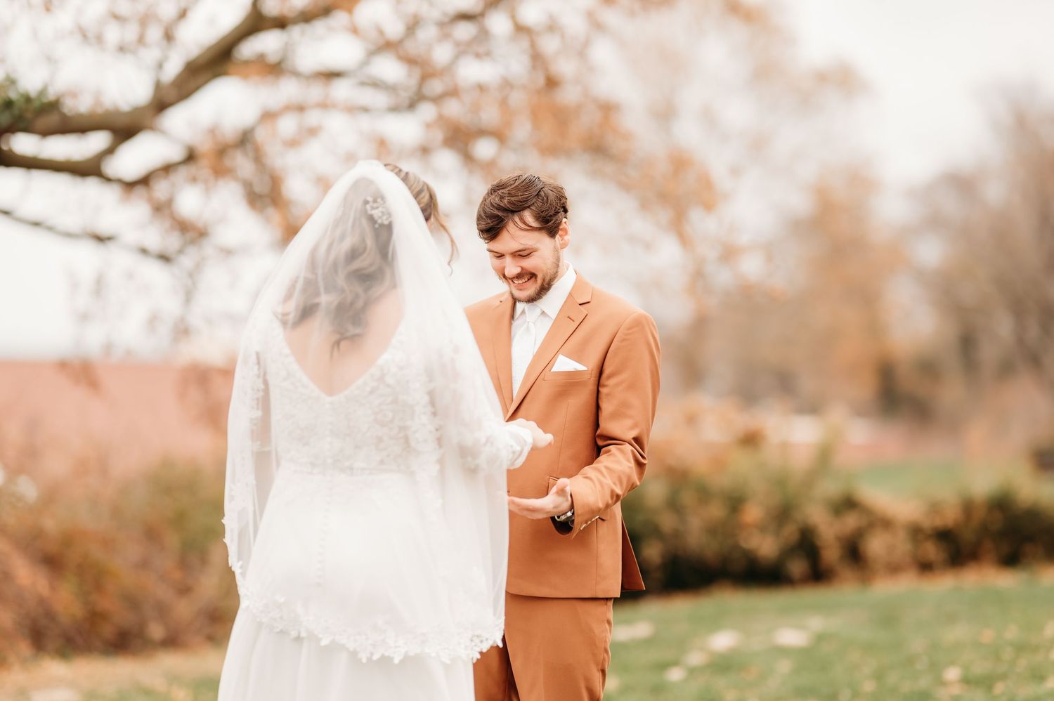A romantic autumn wedding photoshoot in a field with warm golden tones and soft lighting.