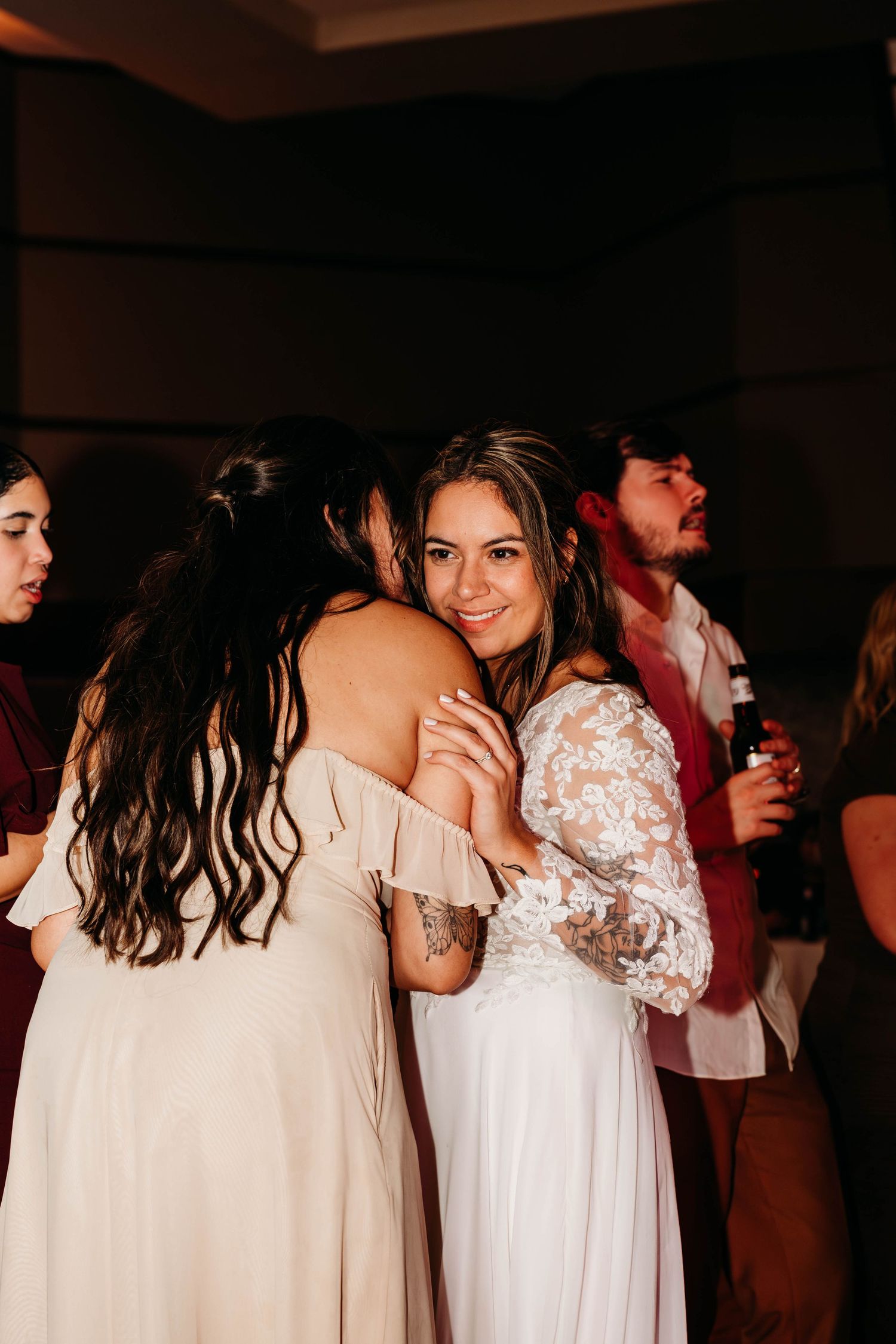 Wedding reception dance floor with couples in white dresses and formal attire.