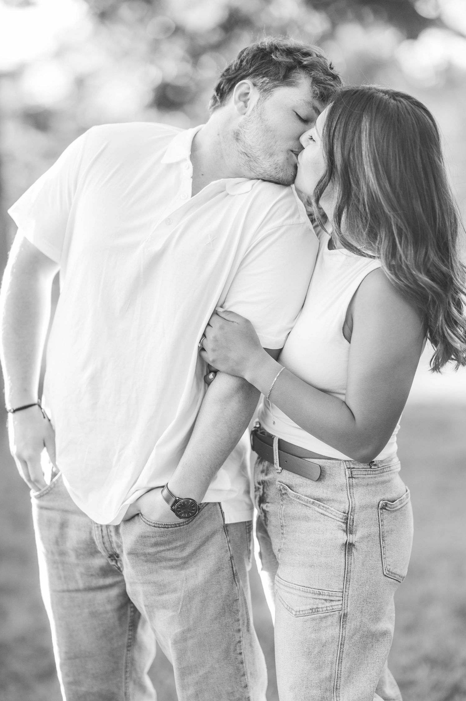Romantic black and white sequence showing a couple embracing in casual attire against a bright background.