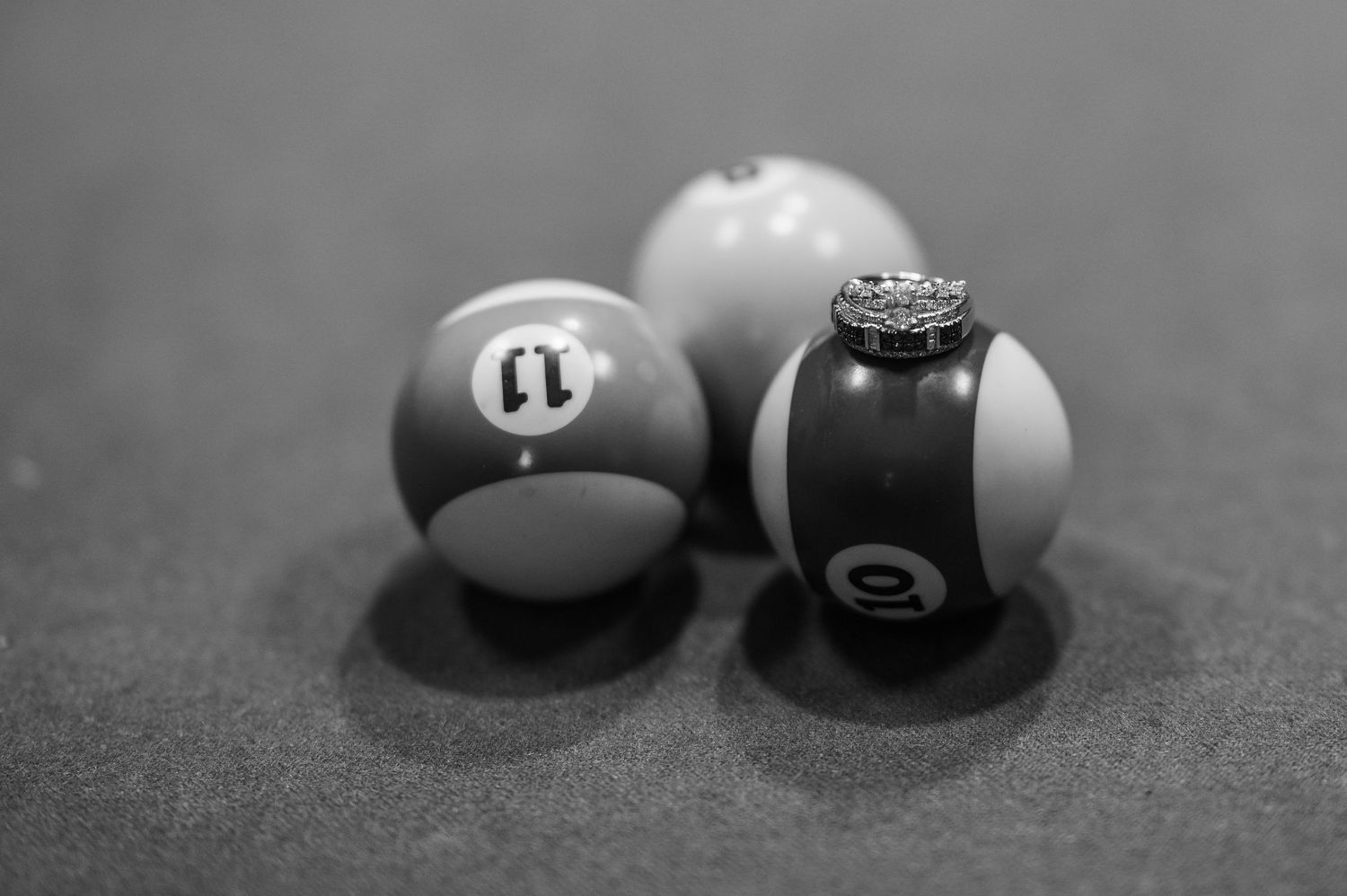 Three pool or billiards balls on a table surface shown in black and white photography.
