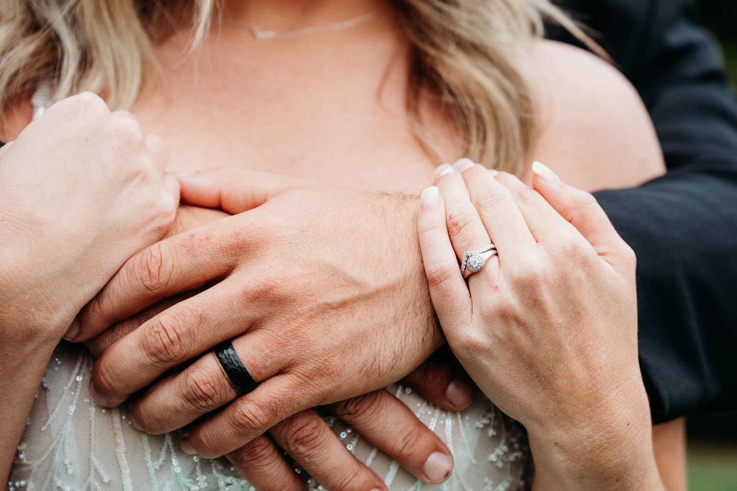 Close-up view of hands with wedding rings exchanging gentle touches and embraces.