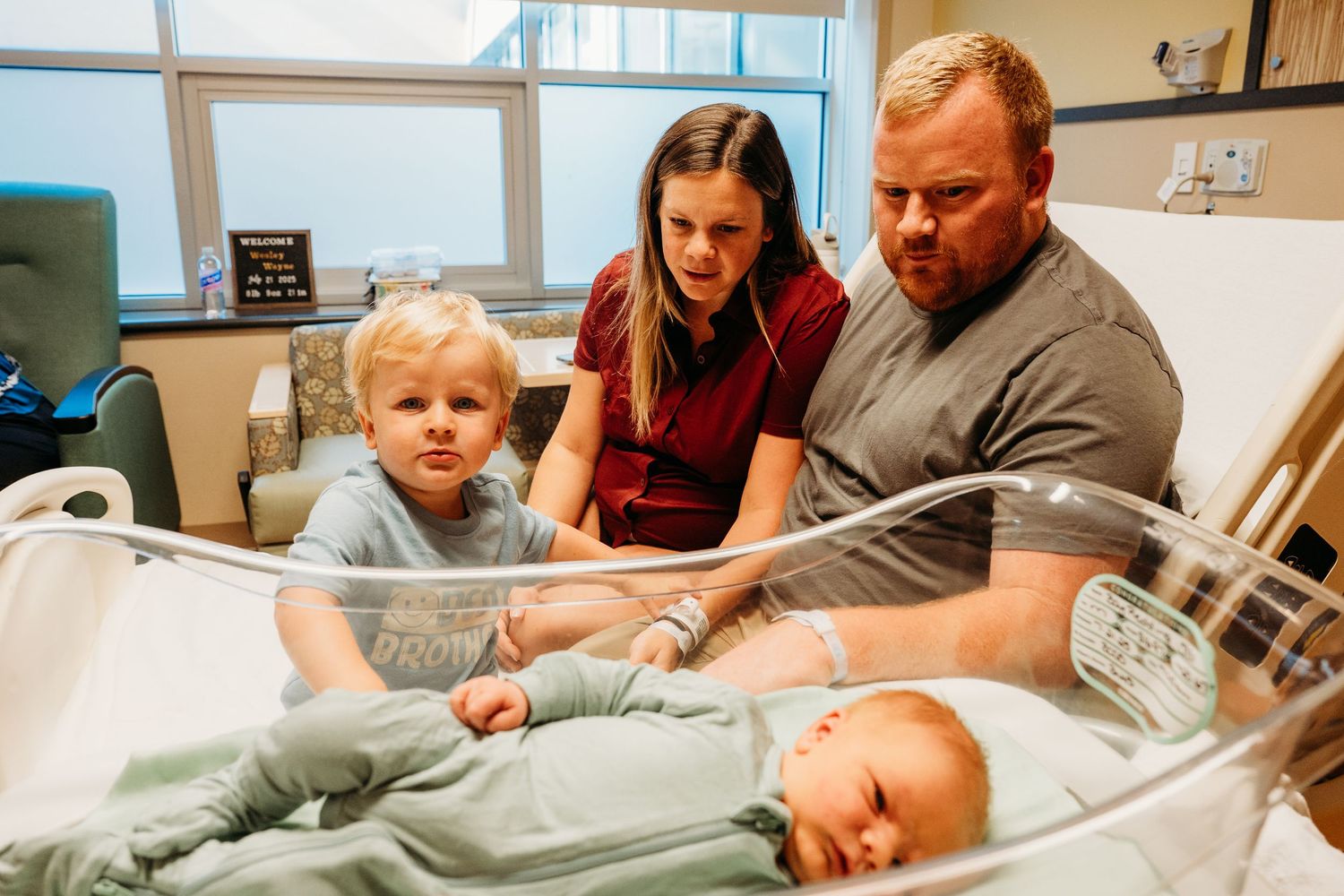 Family members gather around a hospital bed to meet their new addition.