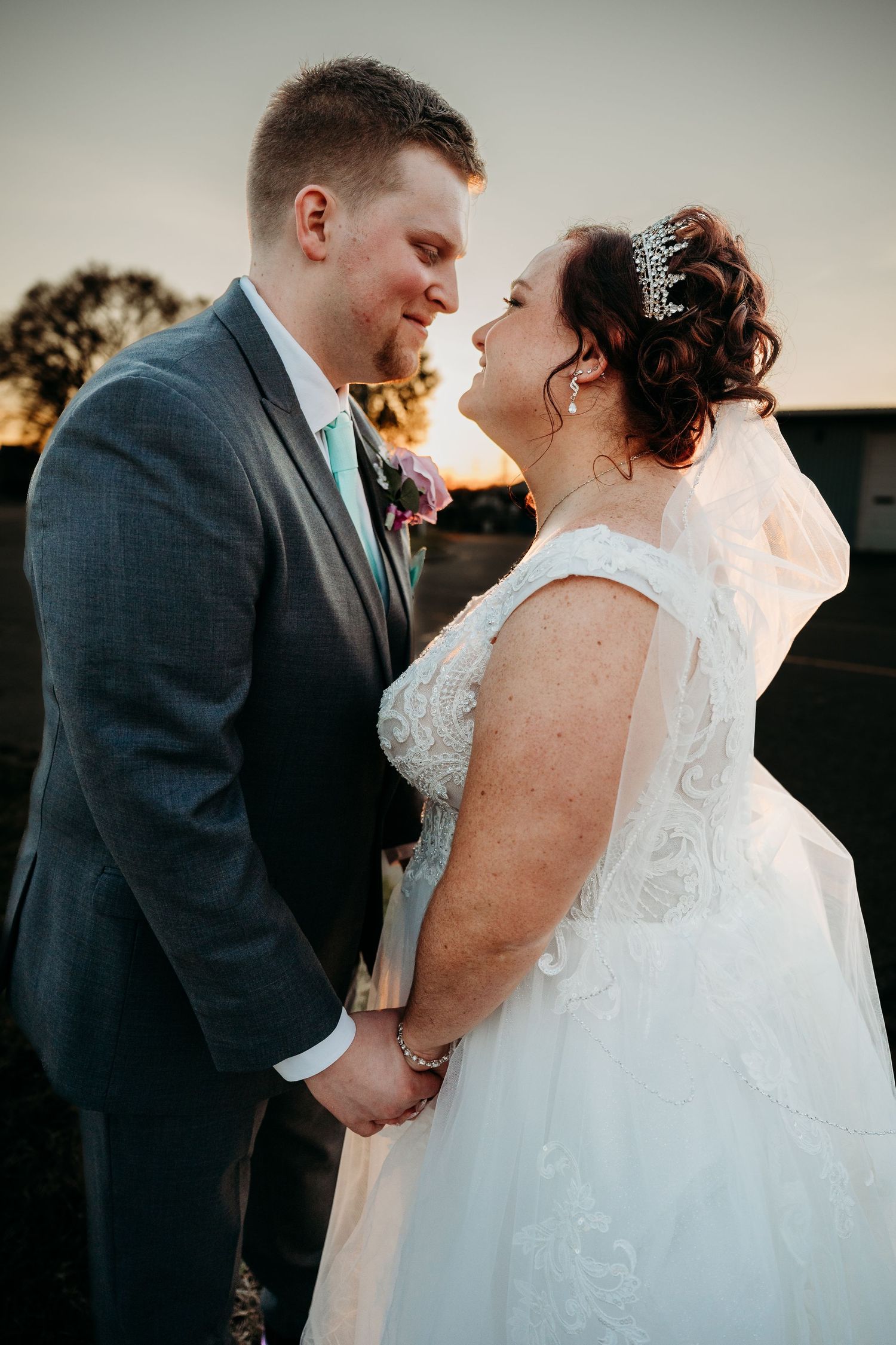 A romantic sunset moment between newlyweds sharing an intimate moment during their wedding celebration.
