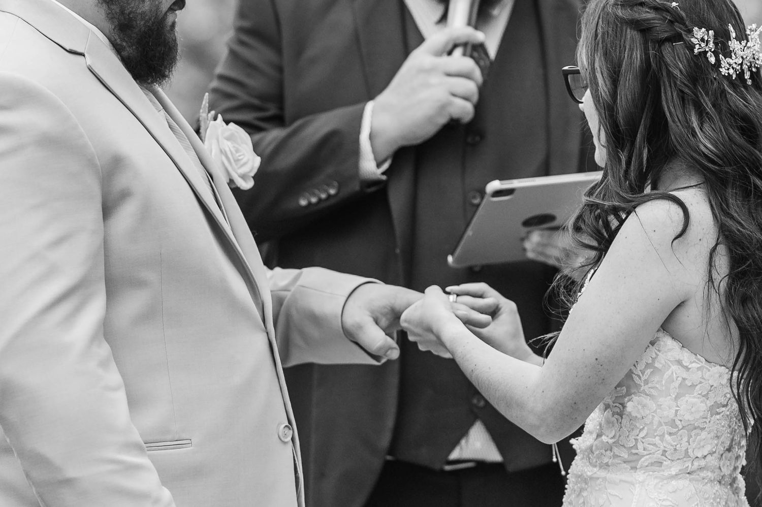 A black and white photo of wedding guests dancing and celebrating together at a reception.