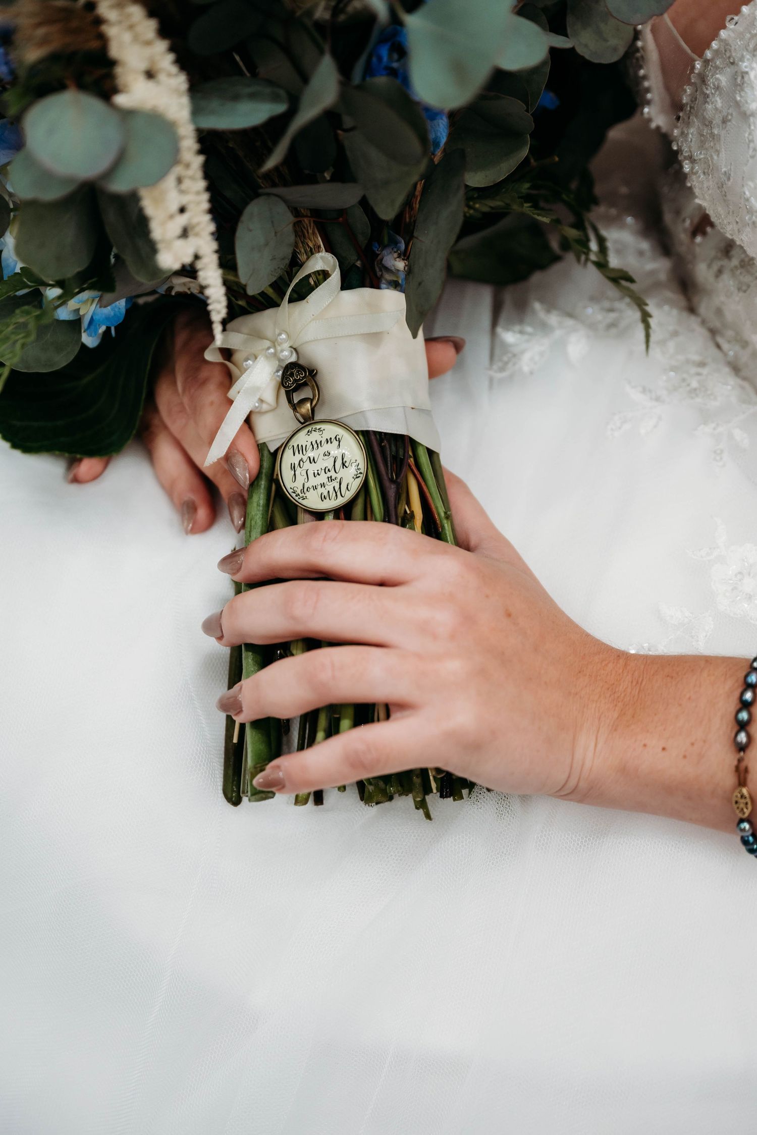 Close-up shots of hands holding a wedding bouquet with white flowers and greenery against a light background.