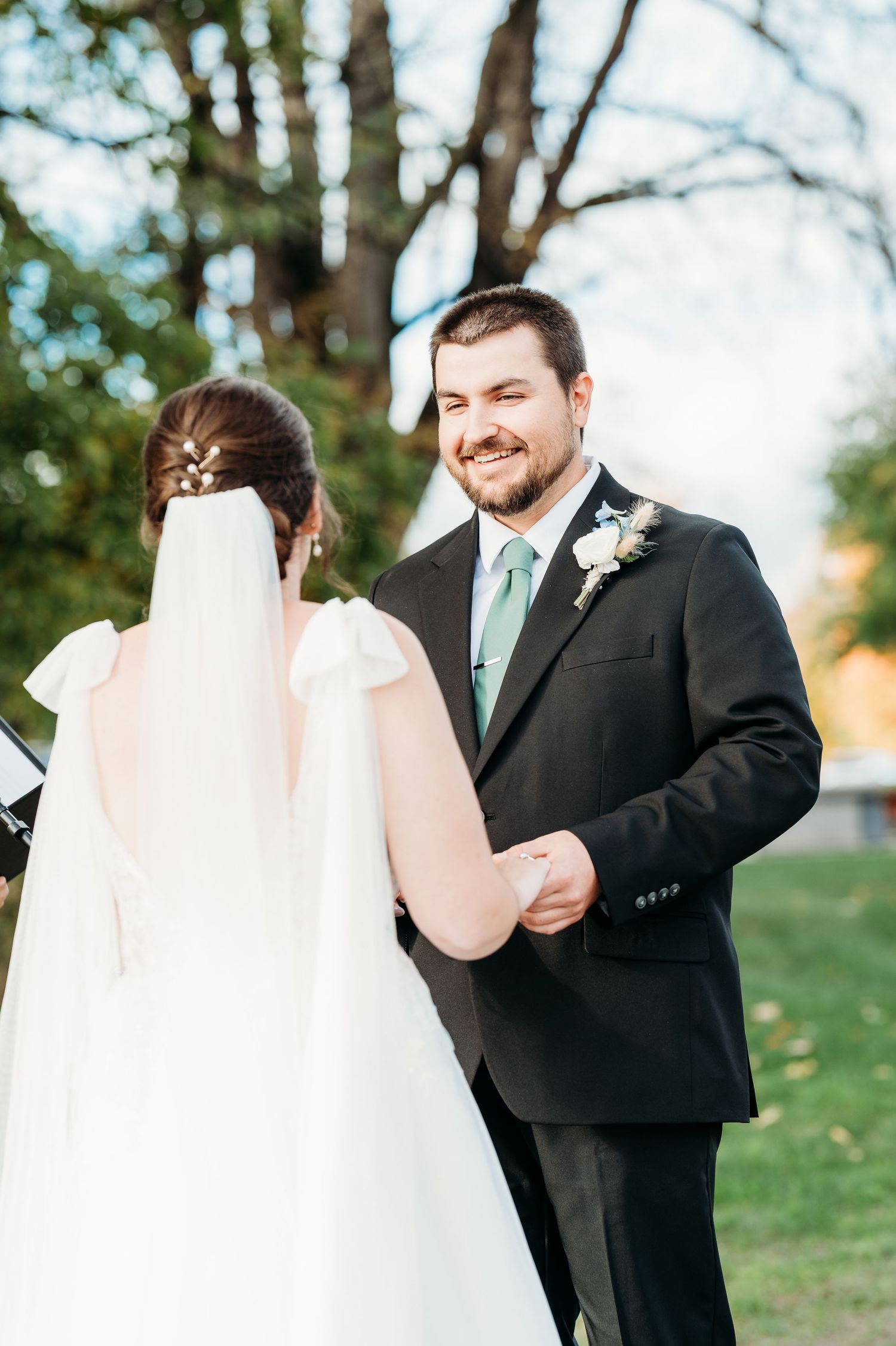 A joyful first look moment between a bride and groom in an outdoor garden setting during their wedding day.