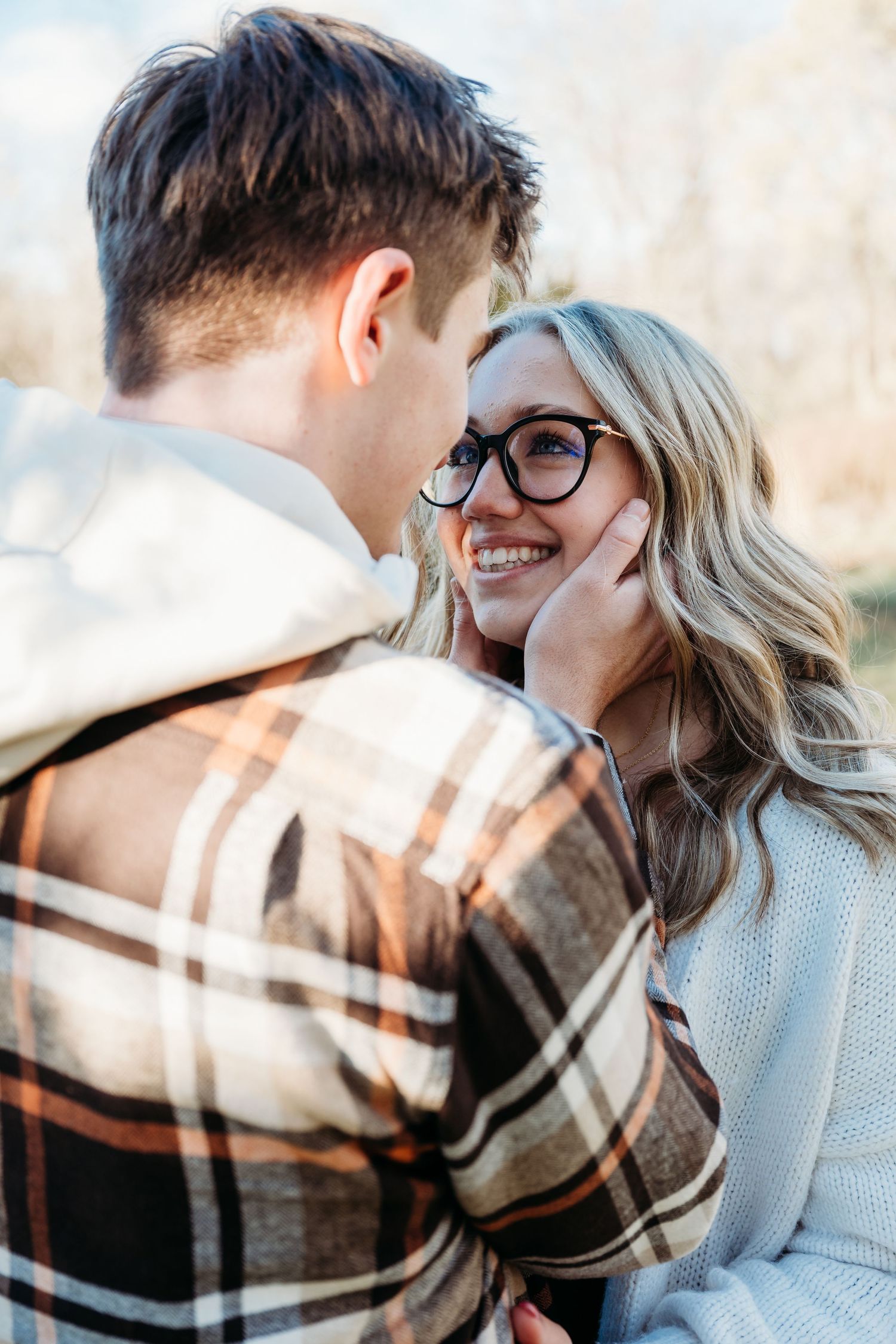 A couple embraces and laughs together during an intimate outdoor winter photo session.