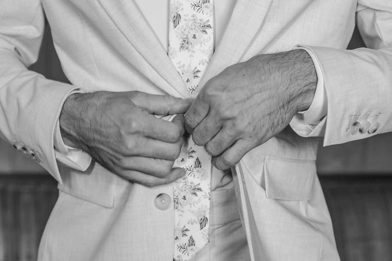 Hands tying a white martial arts belt around a traditional gi uniform during training.