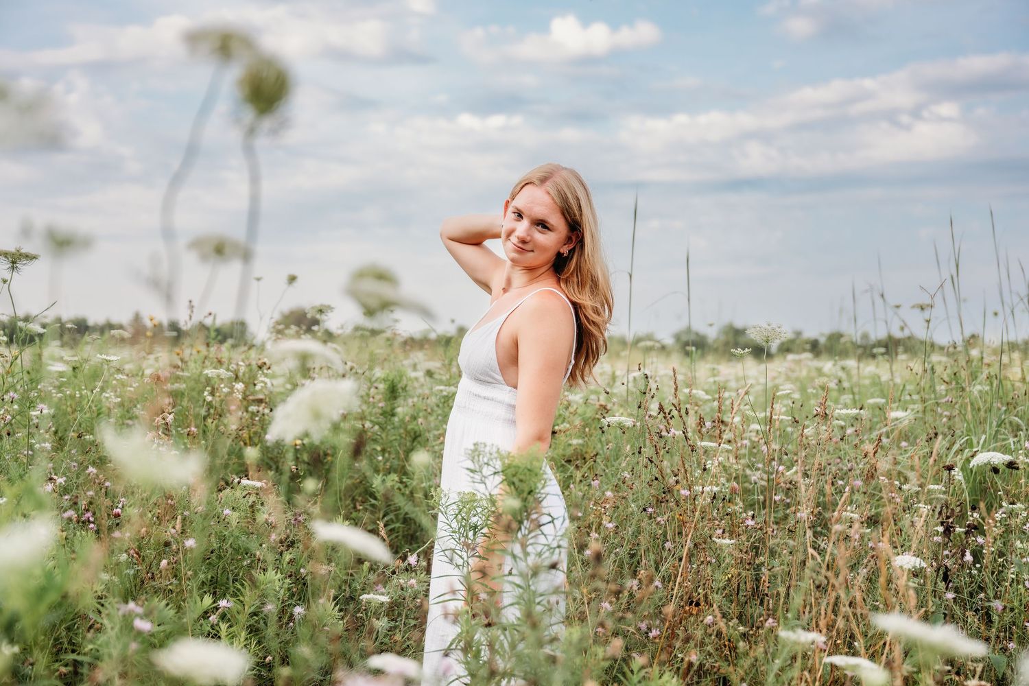 A dreamy outdoor portrait series showing a woman twirling in a field of tall grass and wildflowers.