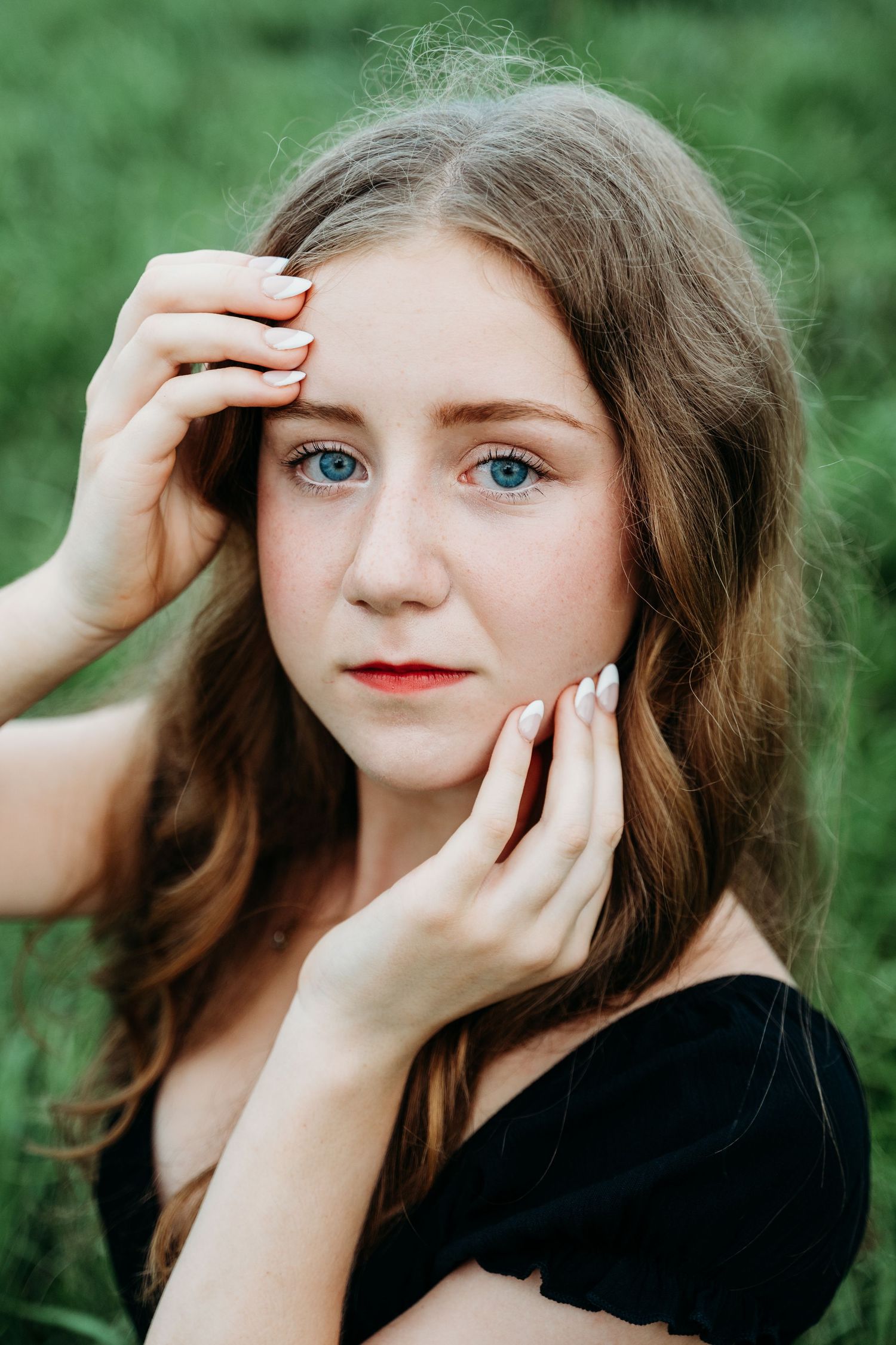 Sequential portrait shots against green foliage showing graceful hand poses and red lipstick.