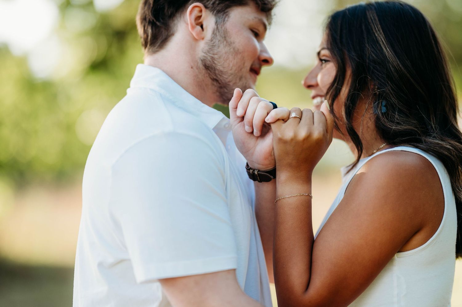 A couple shares an intimate moment during an outdoor photoshoot in natural lighting.