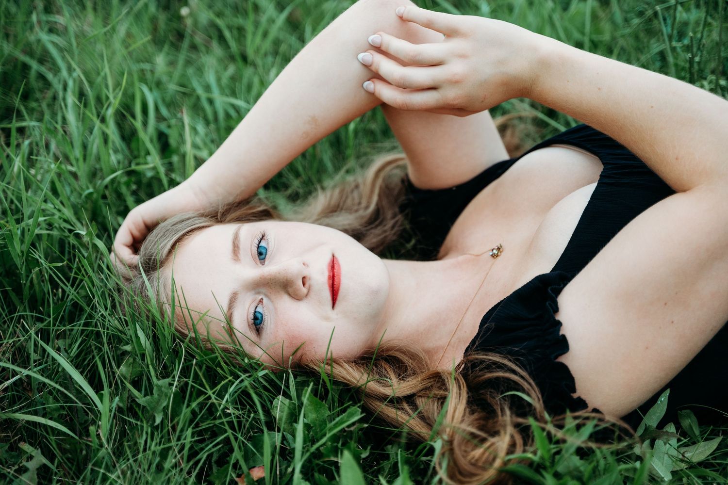 A black-and-white photo series shows a woman in elegant poses lying on grass, creating a dreamy artistic atmosphere.