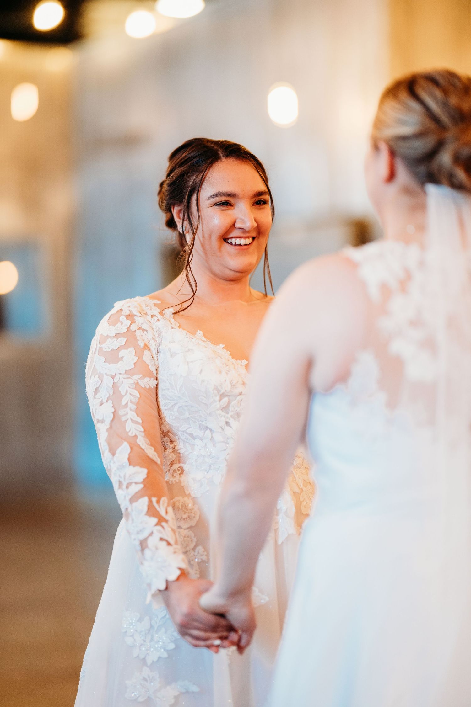 Intimate wedding moment captured with soft lighting as two brides share a tender moment.