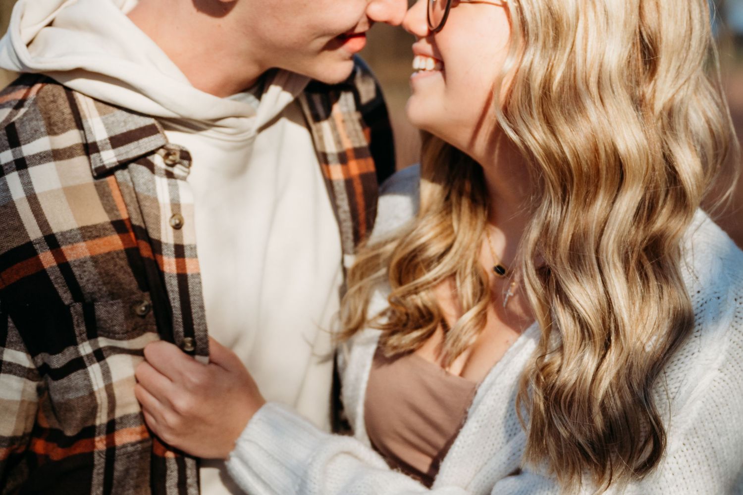 Romantic couple in plaid shirts share tender moments in a series of intimate black and white photographs.