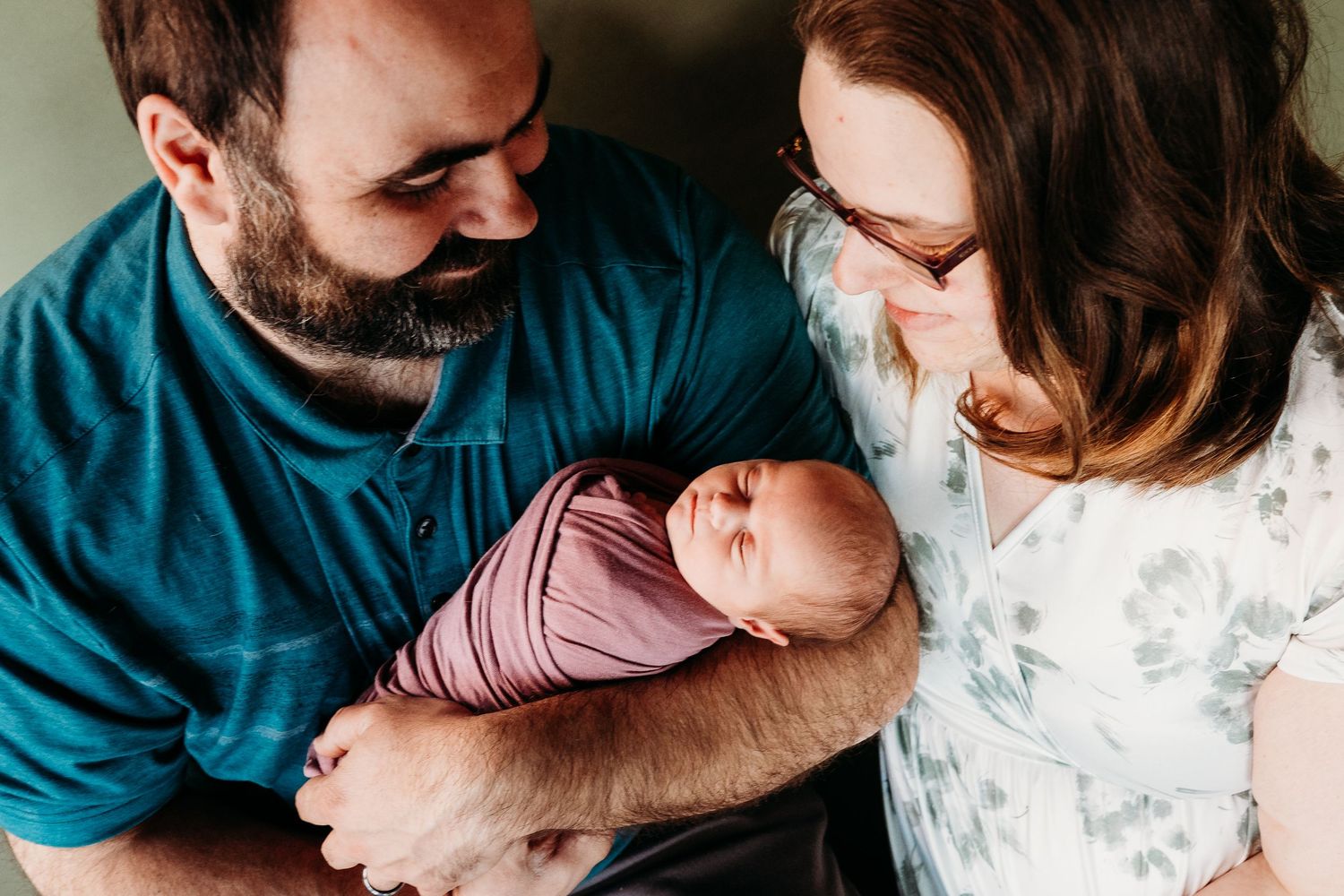 A series of intimate lifestyle portraits showing tender moments between a couple wearing teal and pink tones.