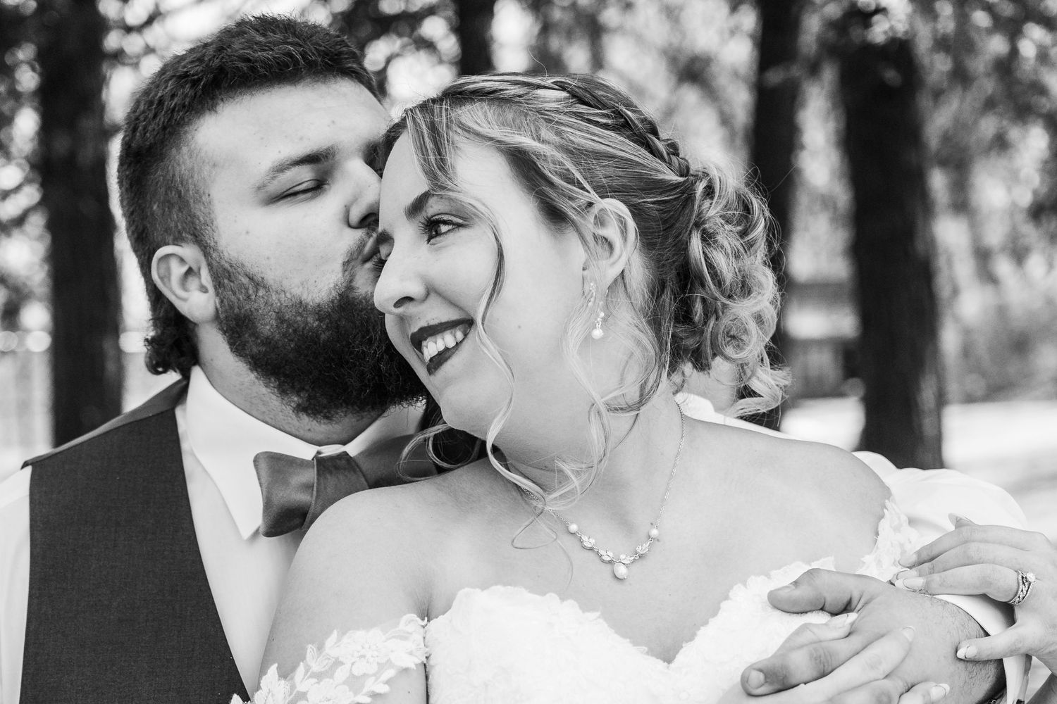 A romantic black and white photo collage shows a couple sharing tender kisses and intimate moments during their wedding celebration.