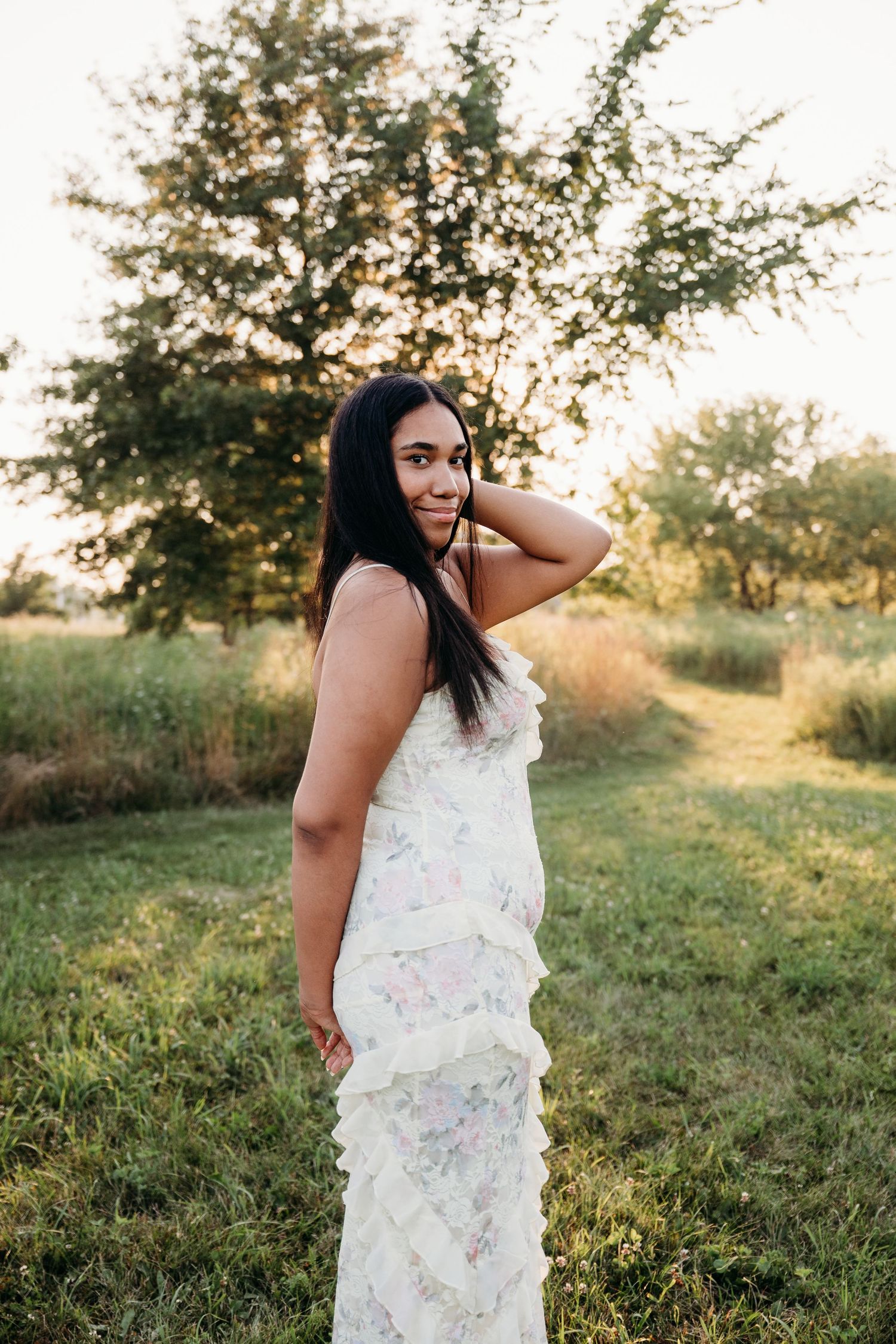Summer sunset photoshoot in grassy field with warm lighting and natural composition.