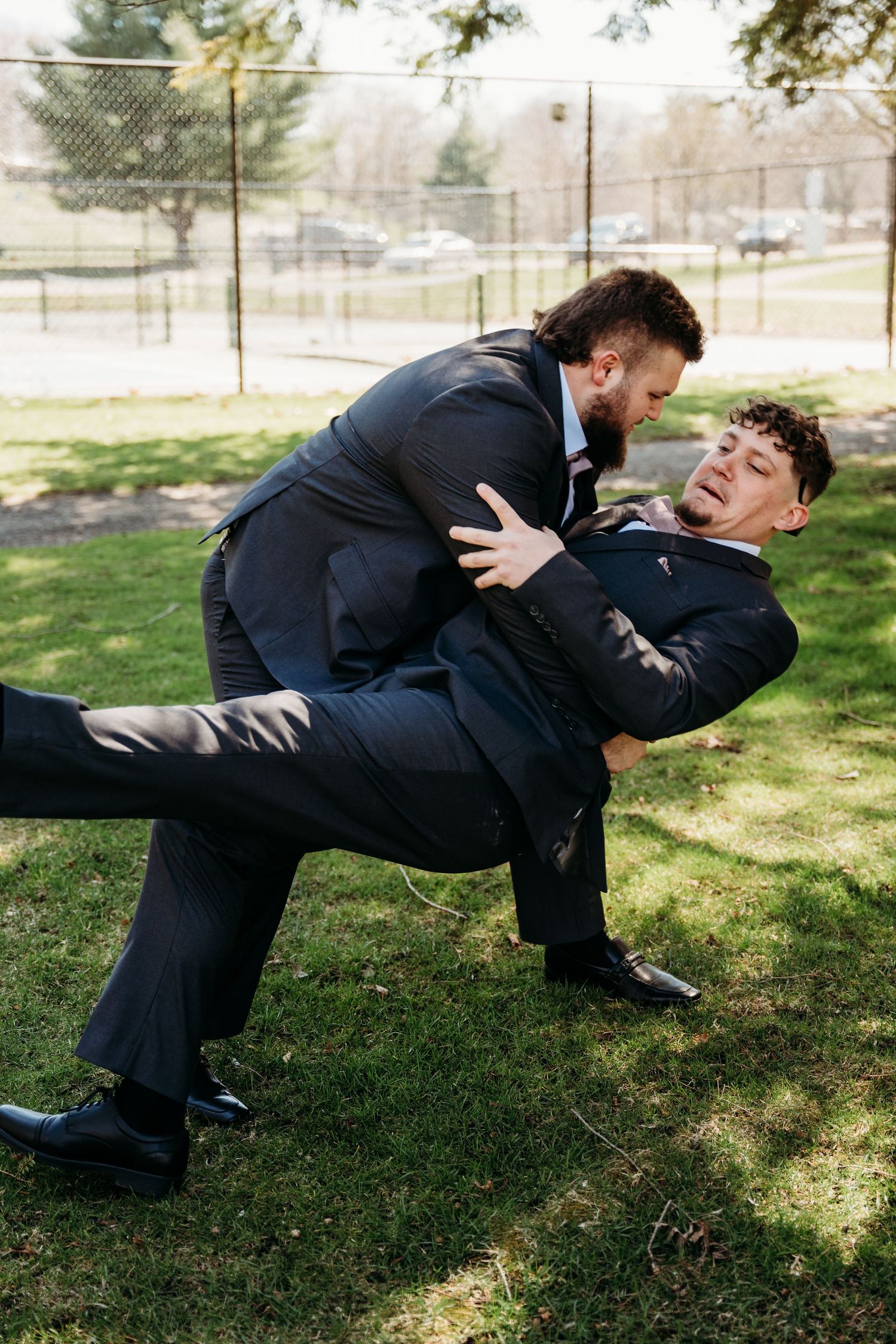 A sequence of four frames shows a person in a business suit falling sideways in slow motion on a grassy lawn.