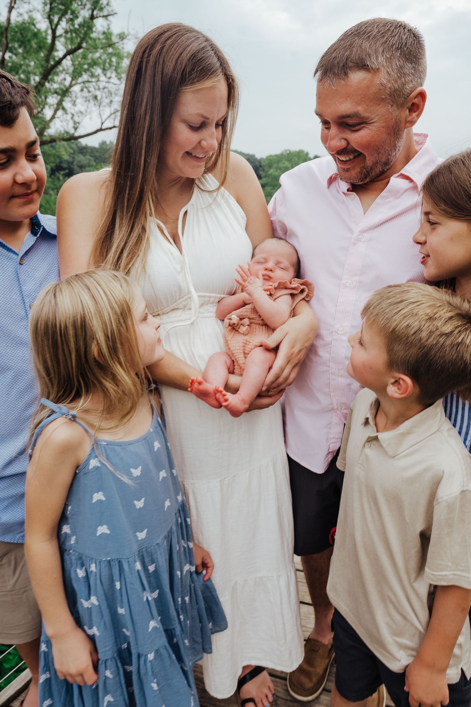 Family members share joyful laughter while gathered together outdoors on a sunny day.