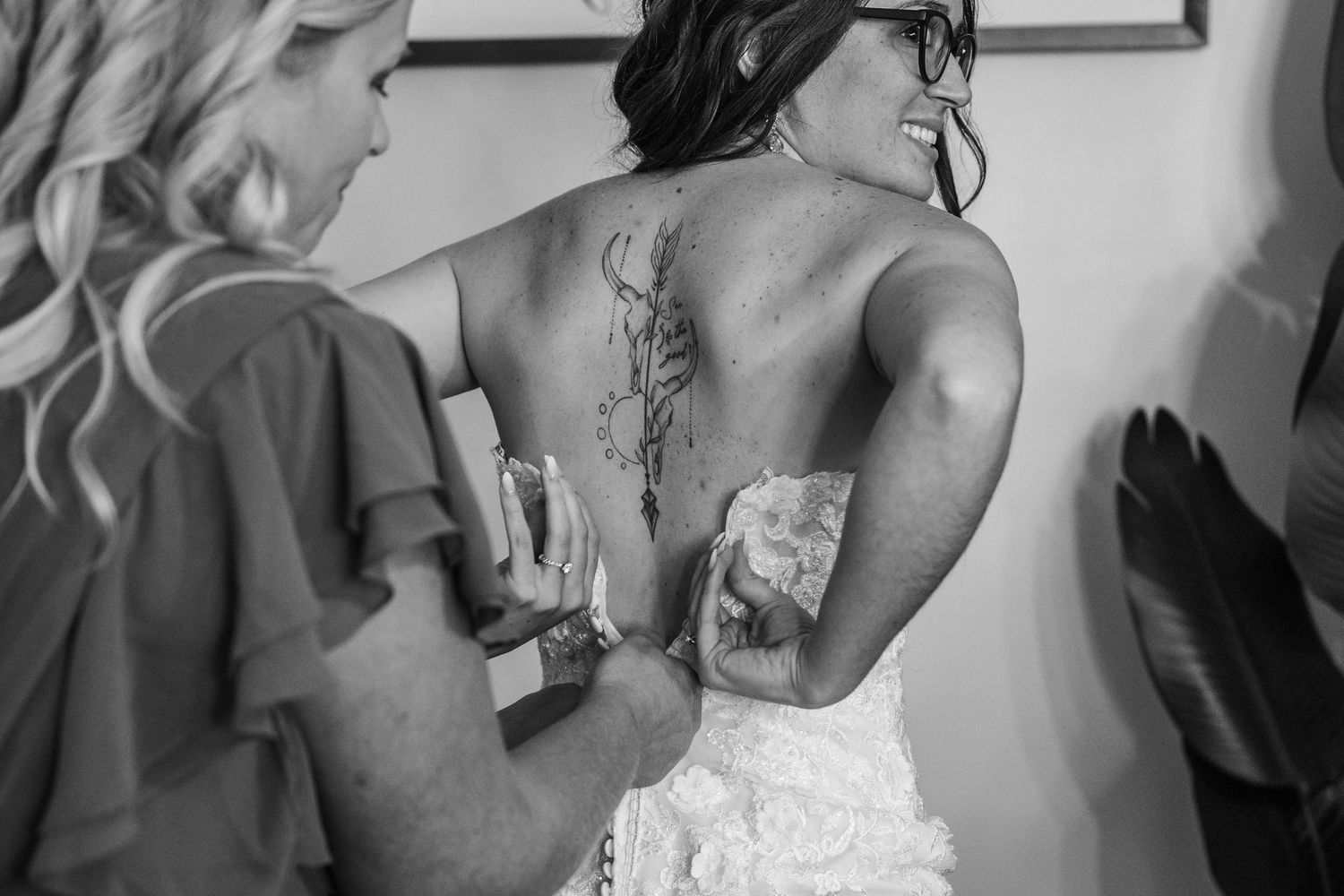 A bride and groom share an intimate kiss while surrounded by wedding guests during their celebration.