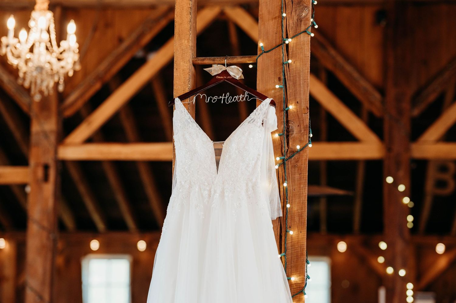 A rustic barn wedding venue decorated with chandeliers and string lights creates a romantic ambiance for the celebration.