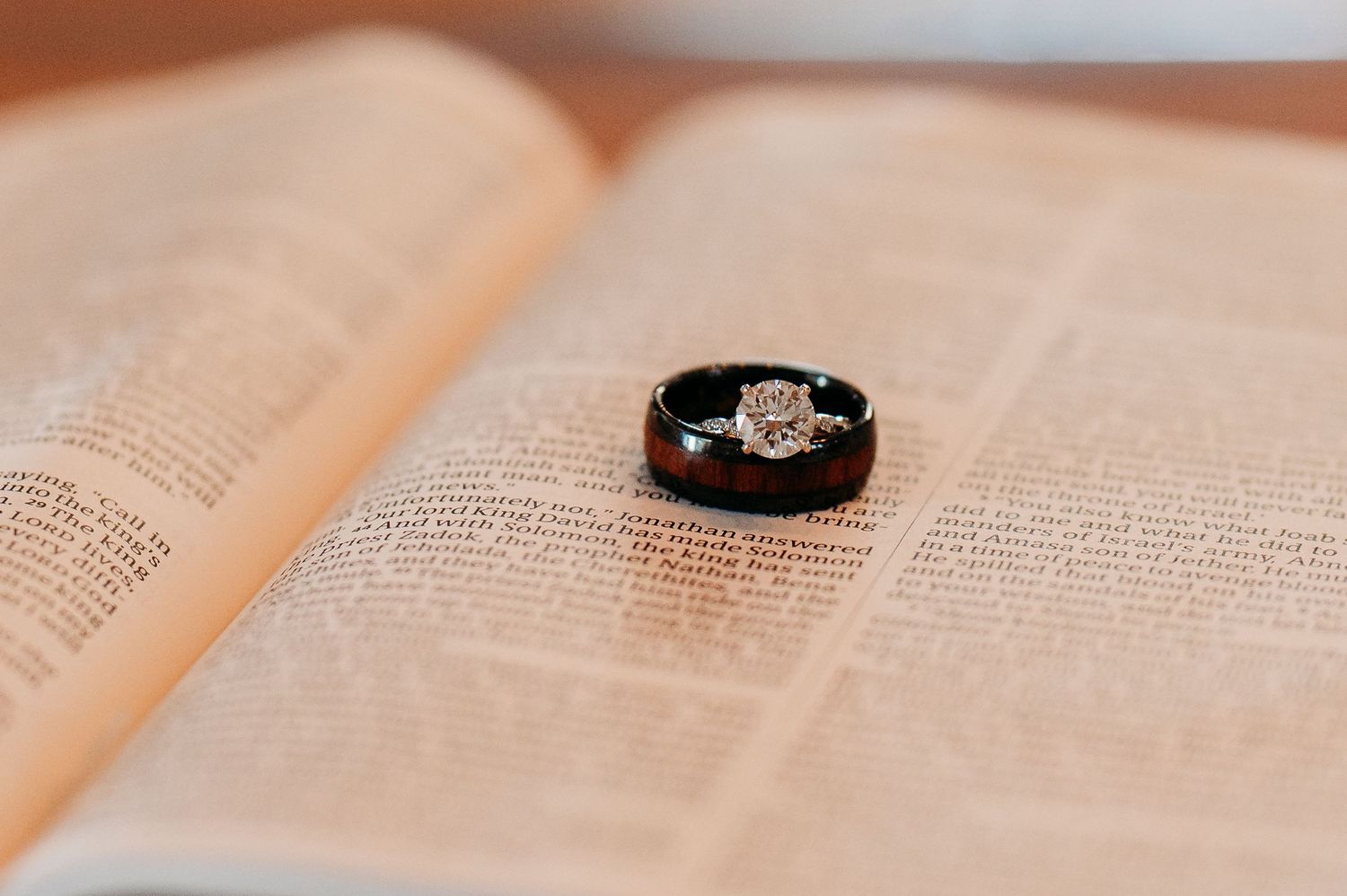 Open book pages with a diamond ring placed on the text creating a romantic composition.