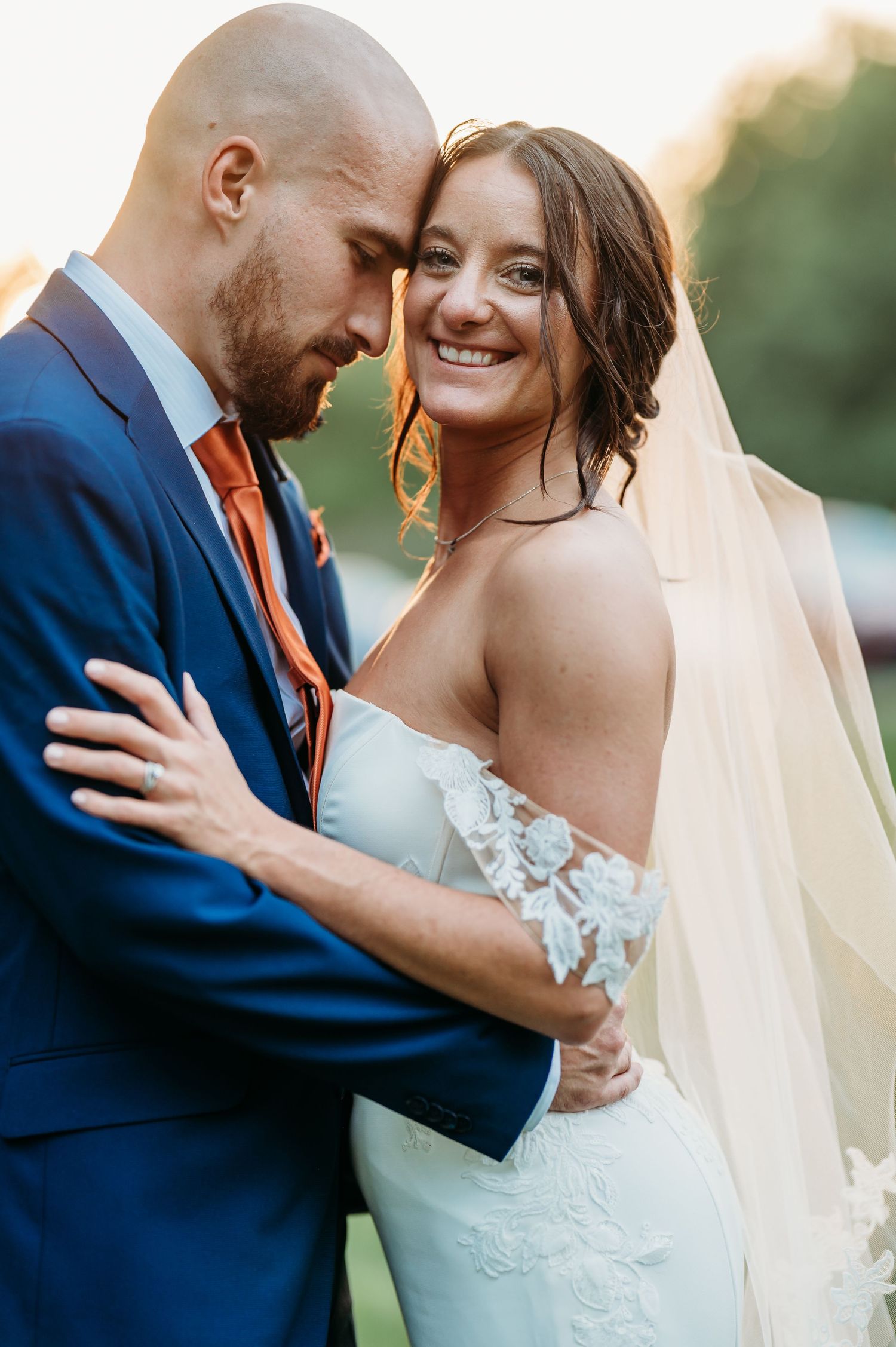 A romantic wedding couple shares intimate moments in a series of close-up photos wearing navy and white attire.