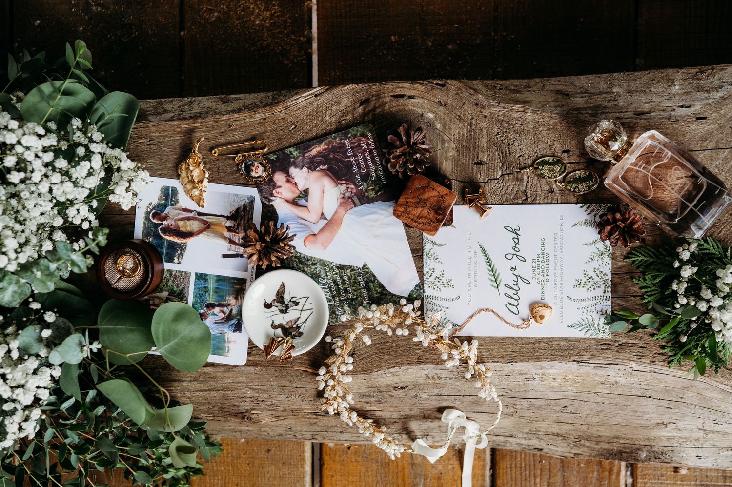 Rustic wedding details with dried flowers, handwritten cards and vintage decor arranged on weathered wood surfaces.