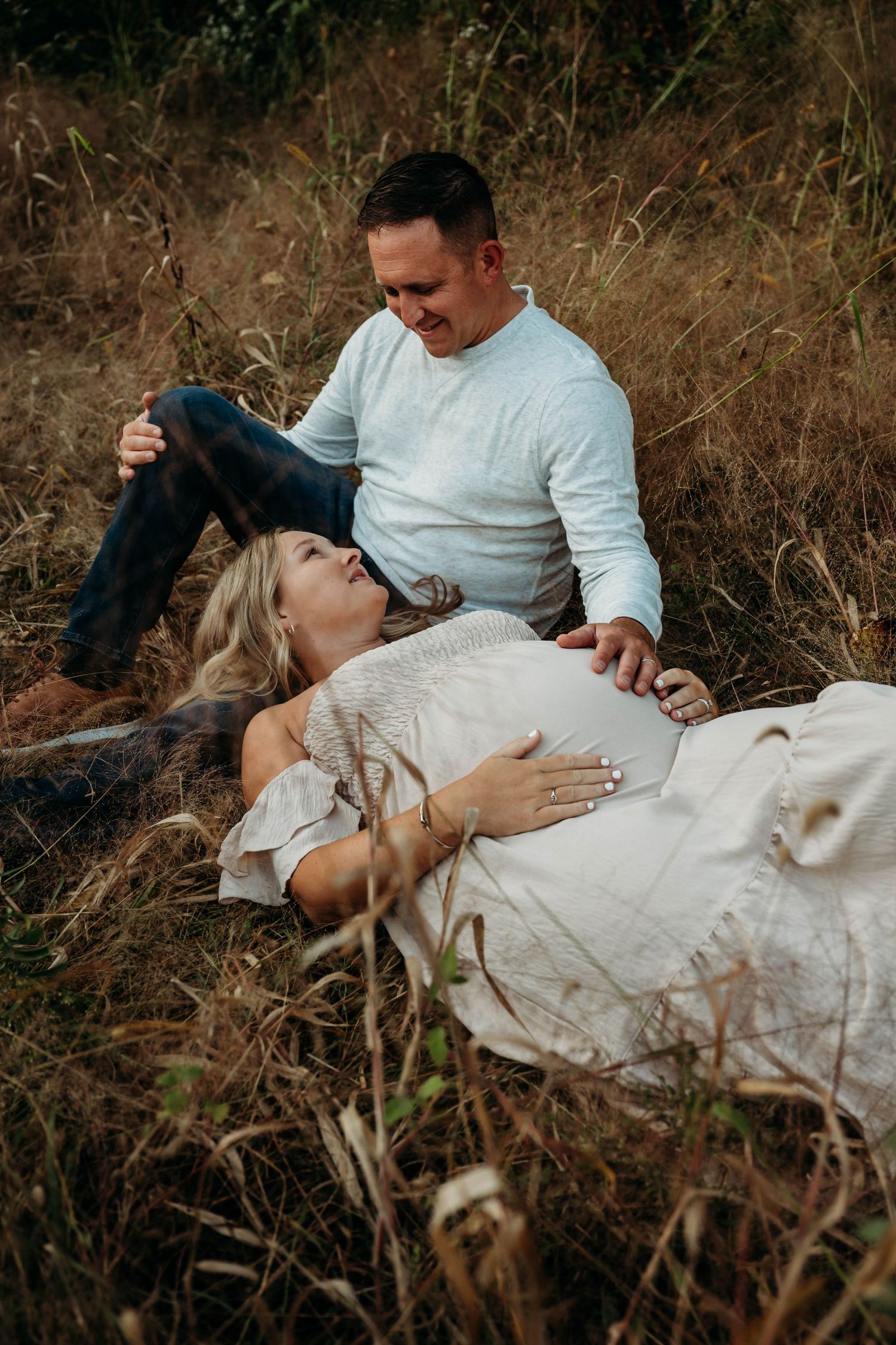 Expectant couple sharing tender moments while looking at sonogram pictures outdoors in nature.