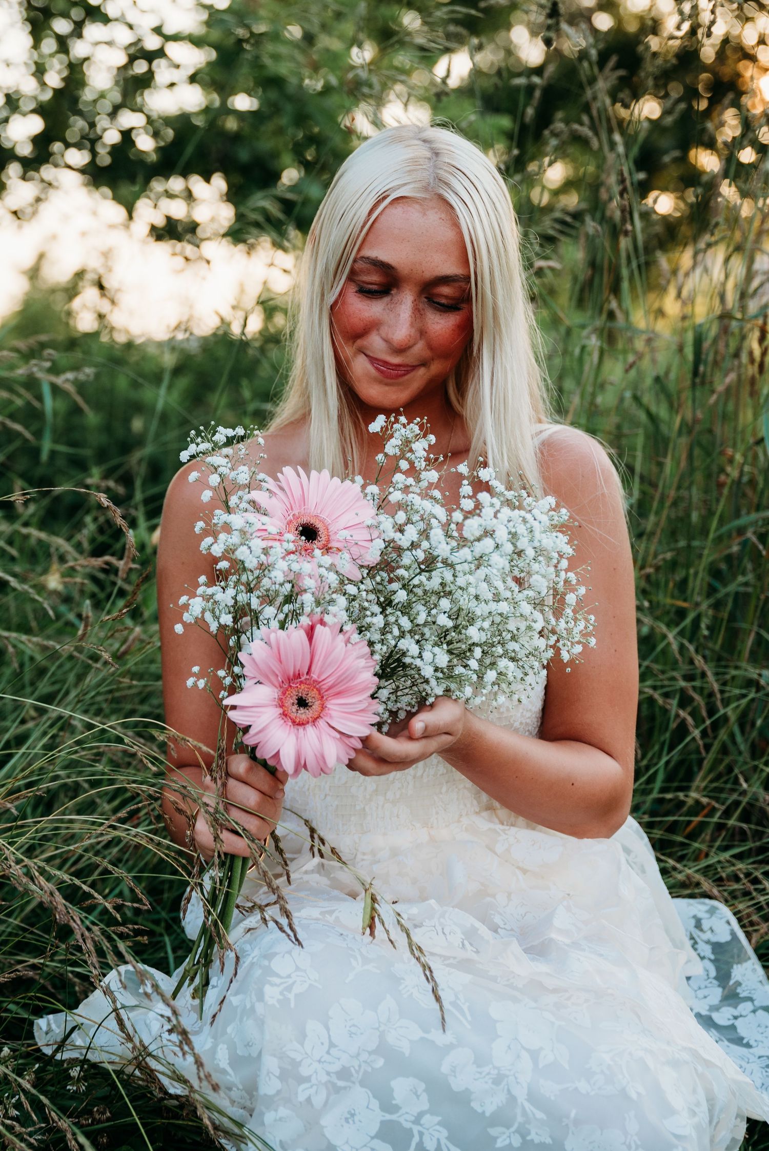 Beautiful bridal portraits in nature showcase delicate baby's breath and pink gerbera daisy flowers.