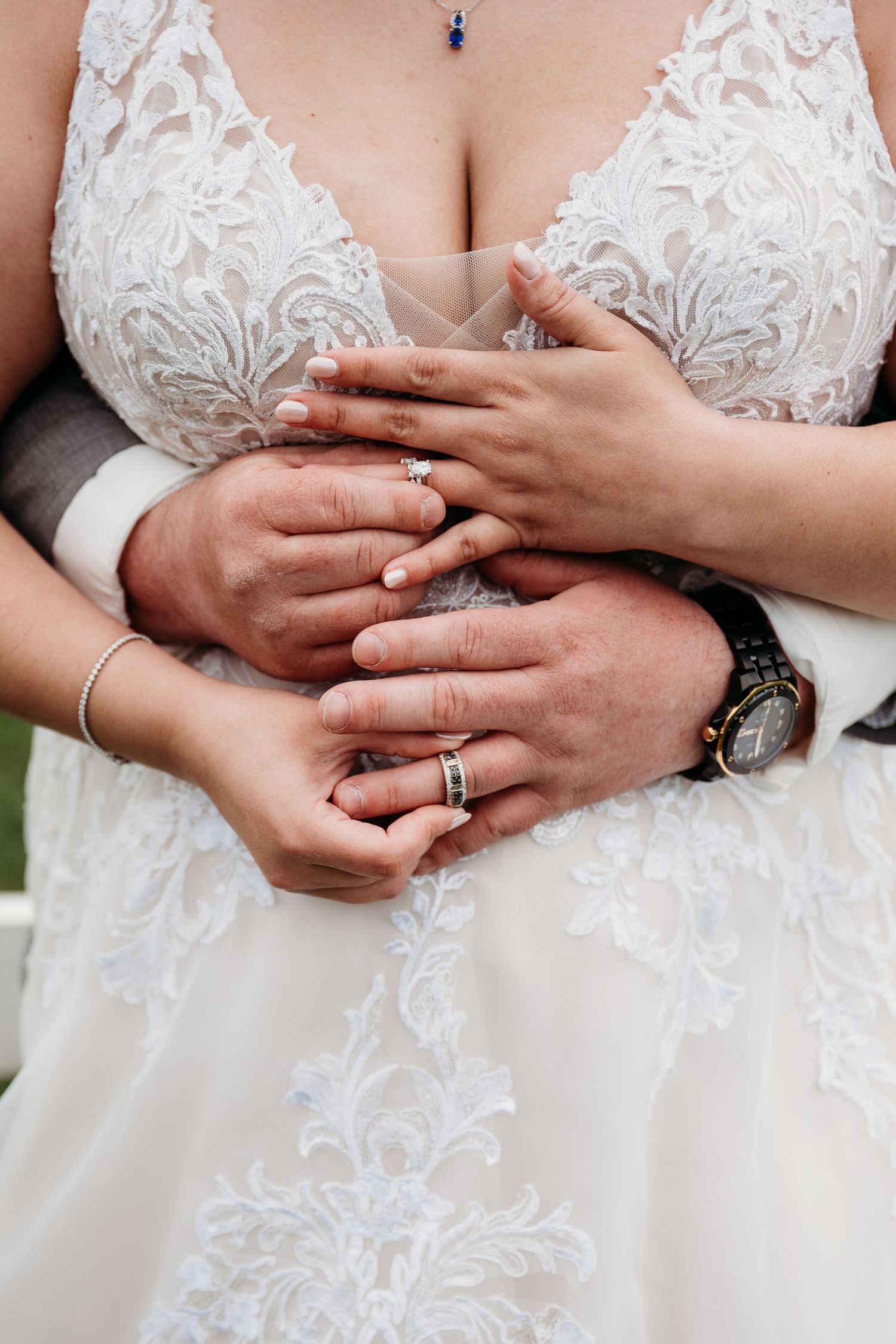 Close-up sequence of hands exchanging wedding rings during a ceremony, showing white lace dress details.