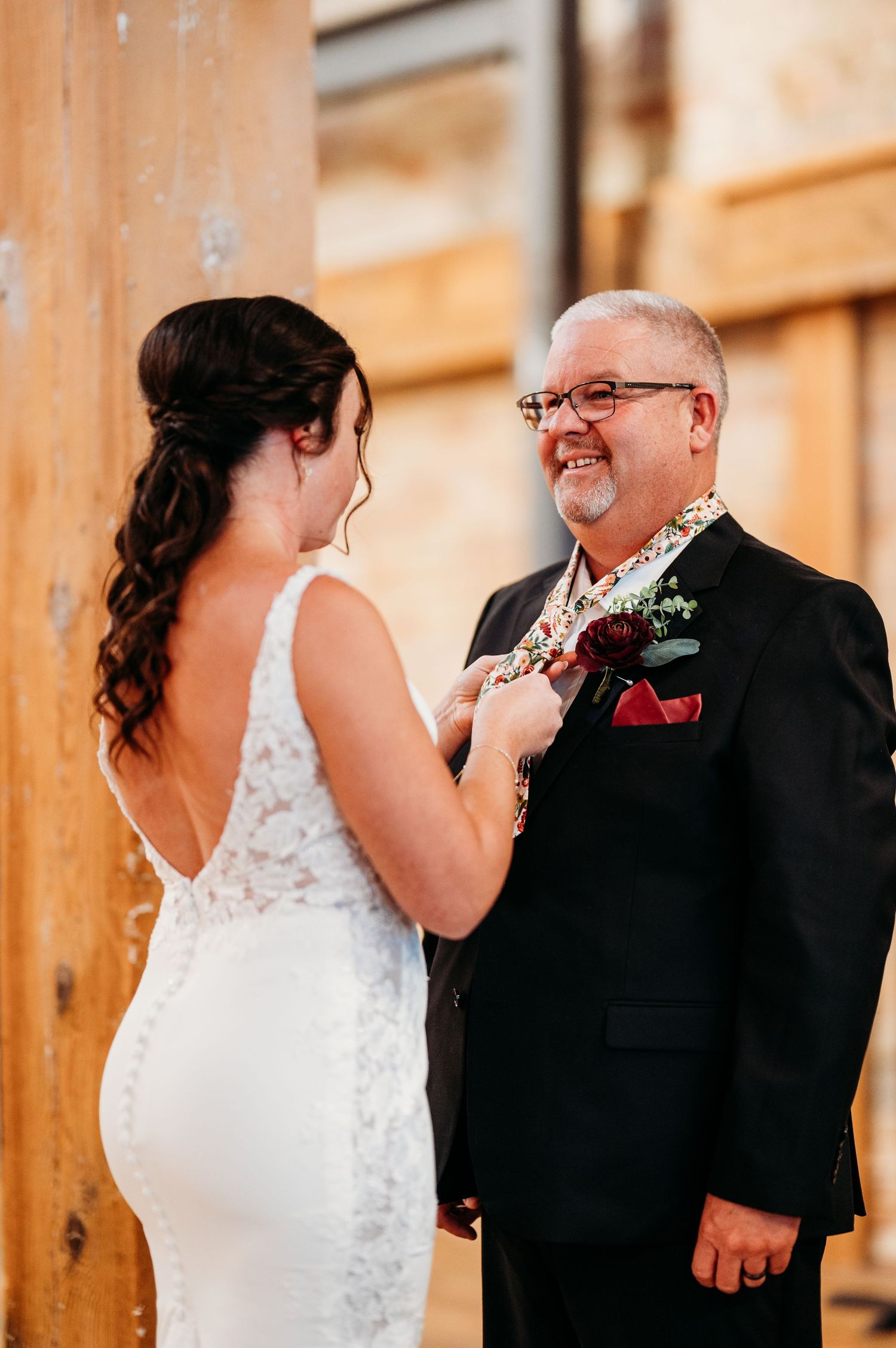 Sweet candid reactions during a first look wedding moment in a warmly lit indoor setting.