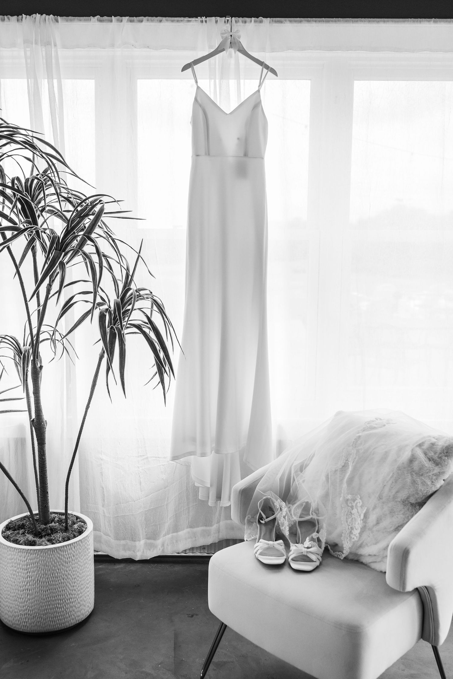 A series of minimalist black and white photos showing wedding dress details, shoes, and indoor plants in natural light.