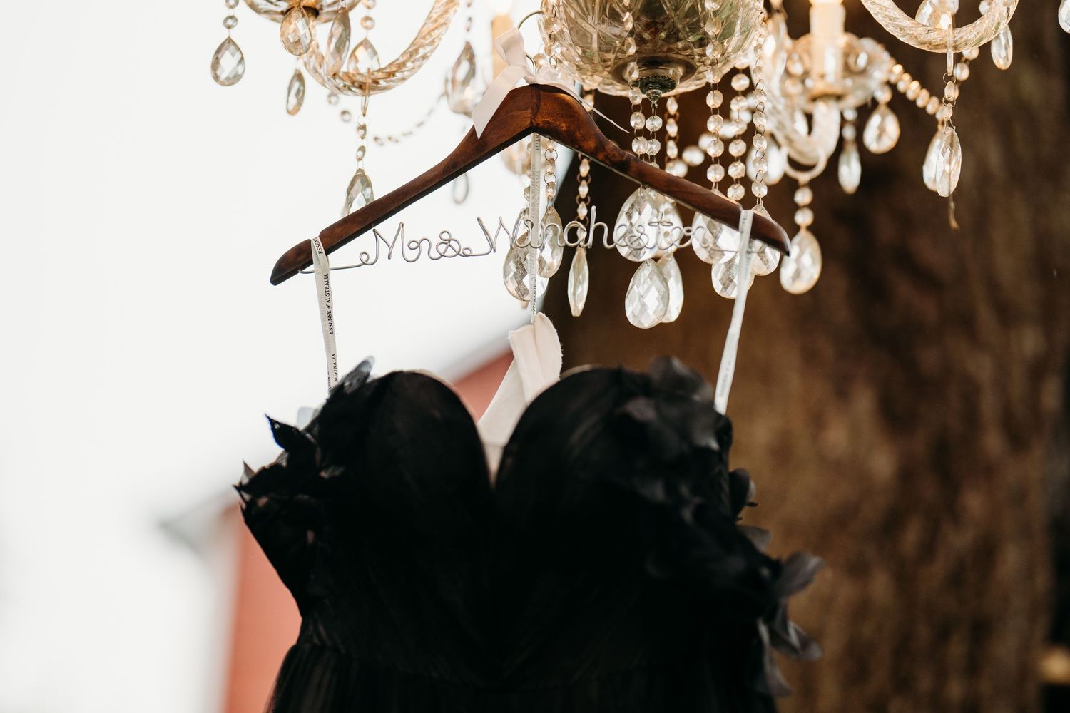 A close up view of crystal droplets hanging from an ornate chandelier with warm lighting.