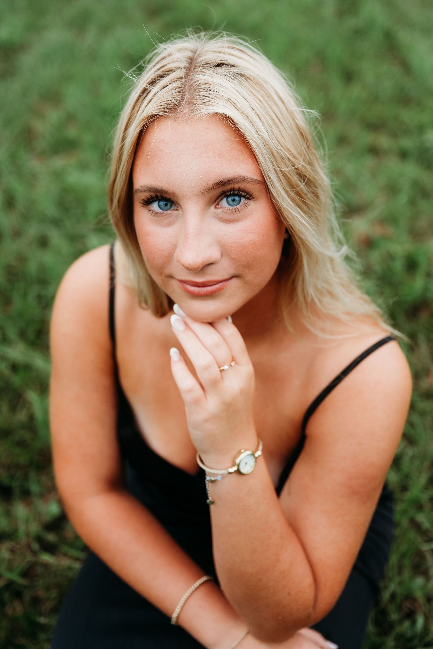 Portrait session in lush green grass with black top and natural outdoor lighting.