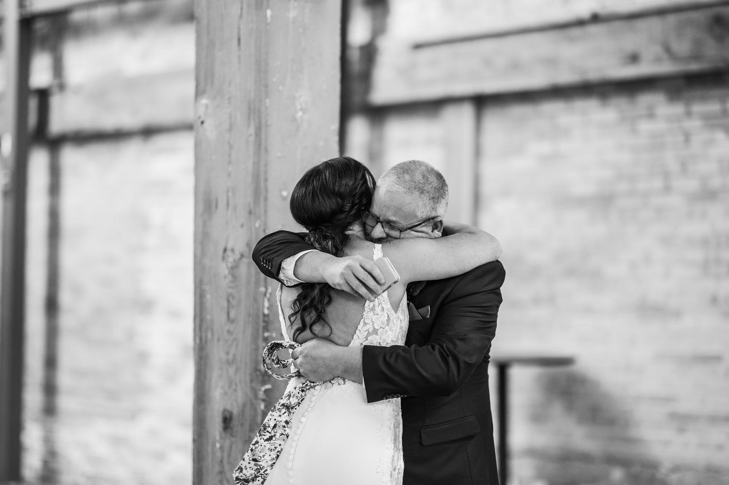Black and white photo of a bride and groom sharing a tender embrace on their wedding day.