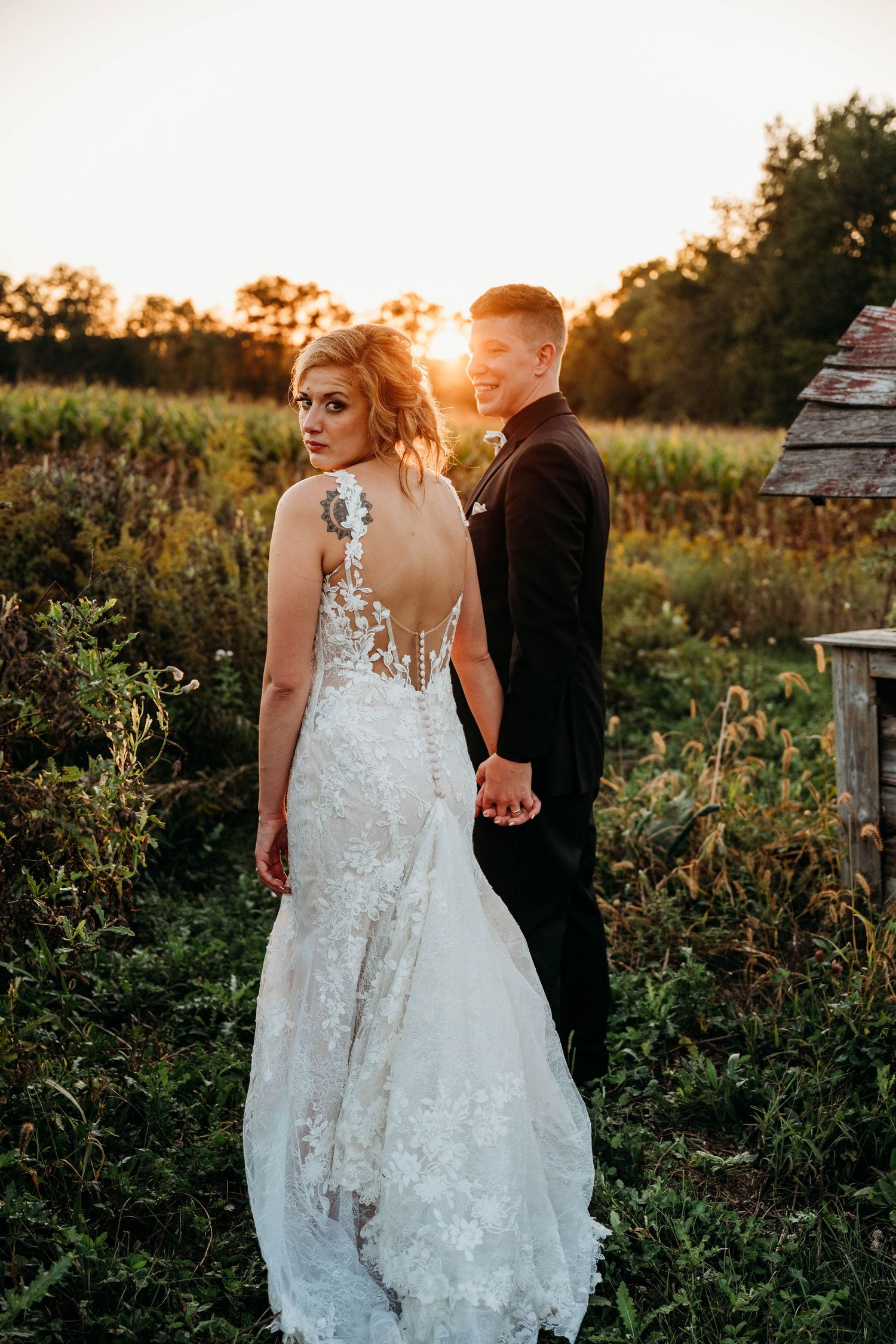Sunset wedding portrait showing intricate lace back detail of bridal gown.