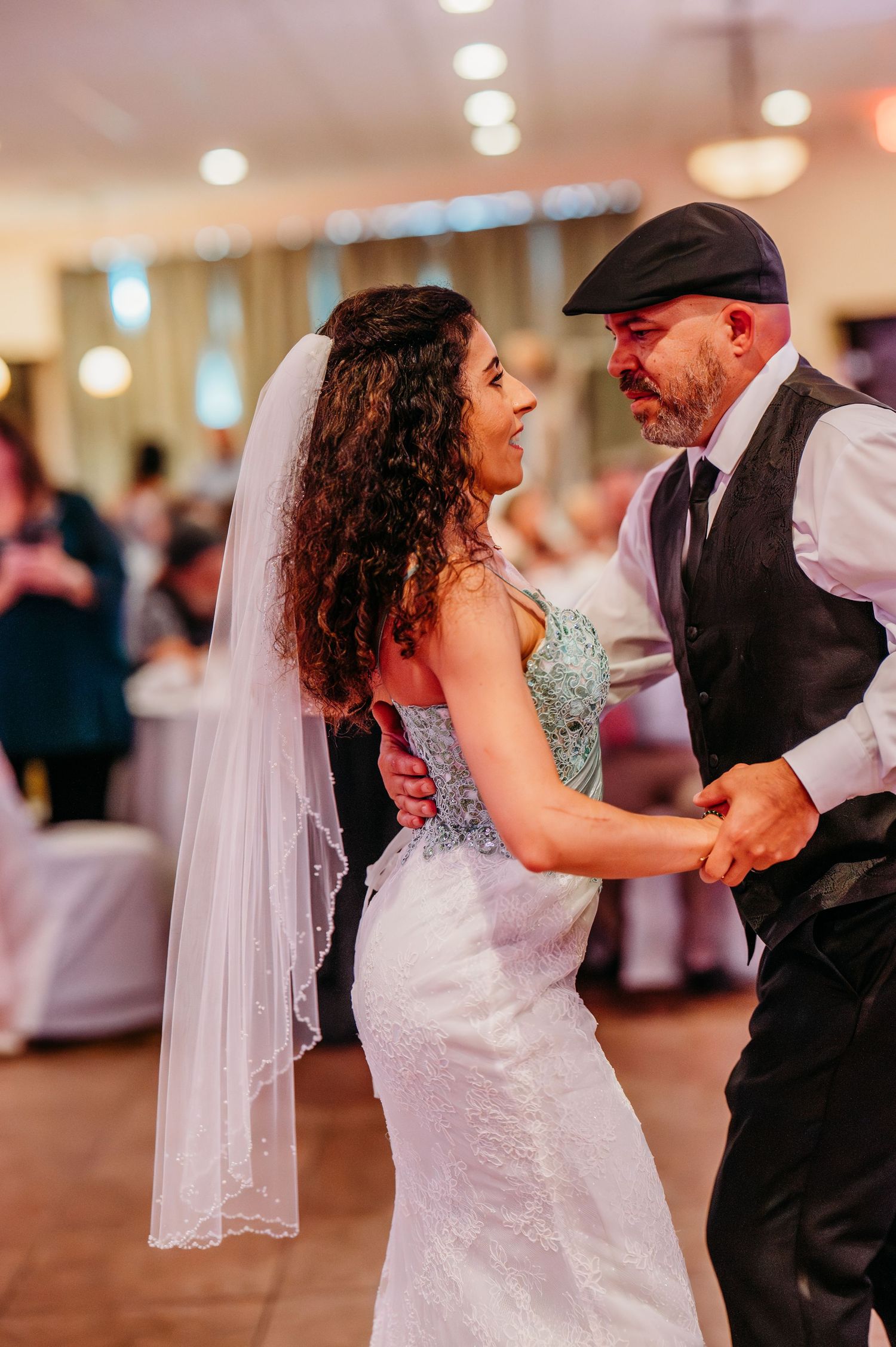 A father-daughter wedding dance sequence showing tender moments as they move across the dance floor.