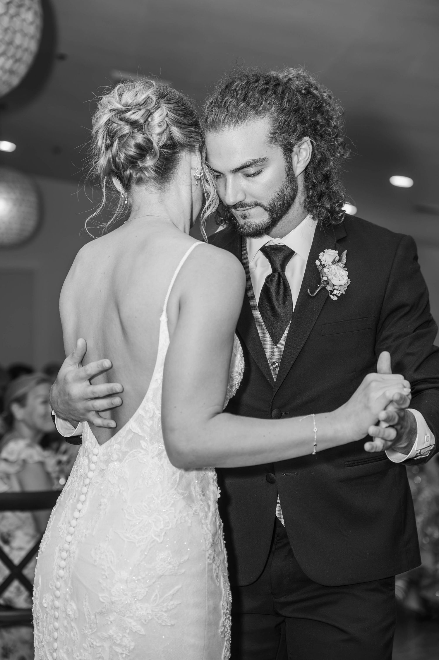 Black and white photo of bride and groom sharing their first dance at wedding reception.