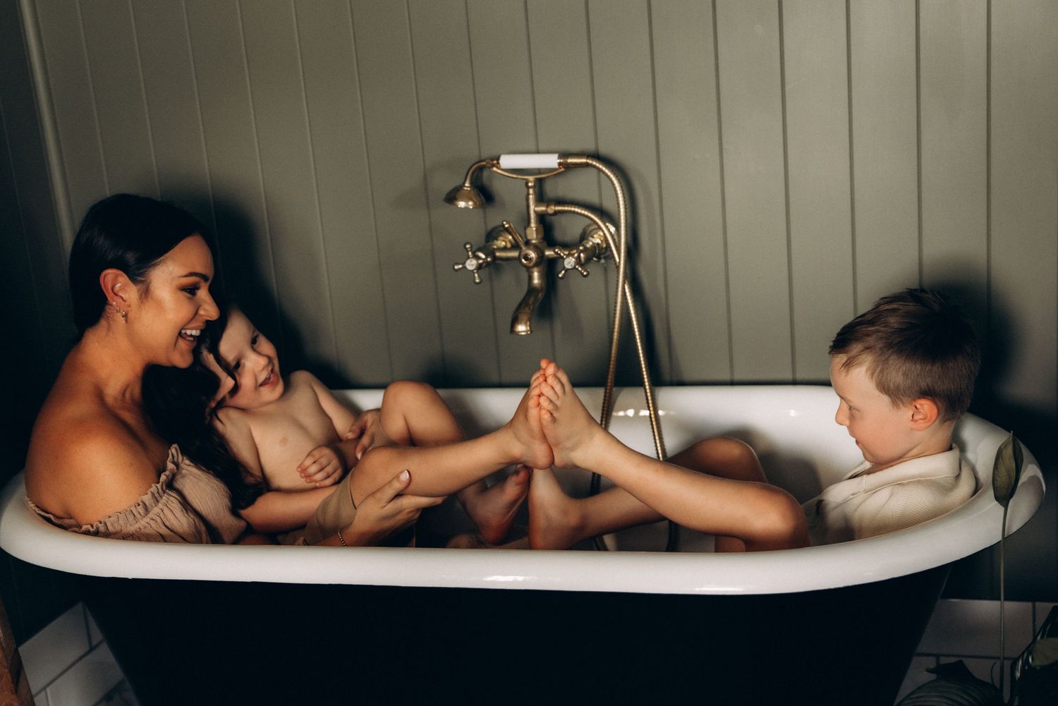 Series of intimate bathtub photos with moody lighting and vintage style.